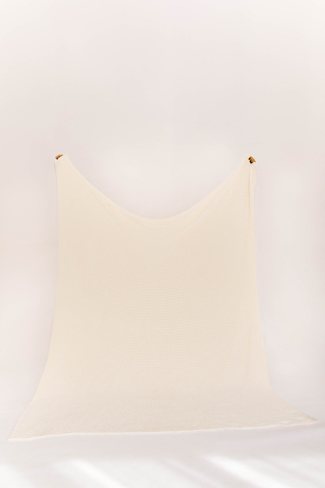 oversized cream blanket on a white wall