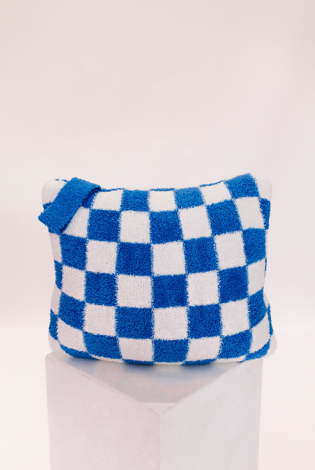 Blue and white checkered pillow on a white background