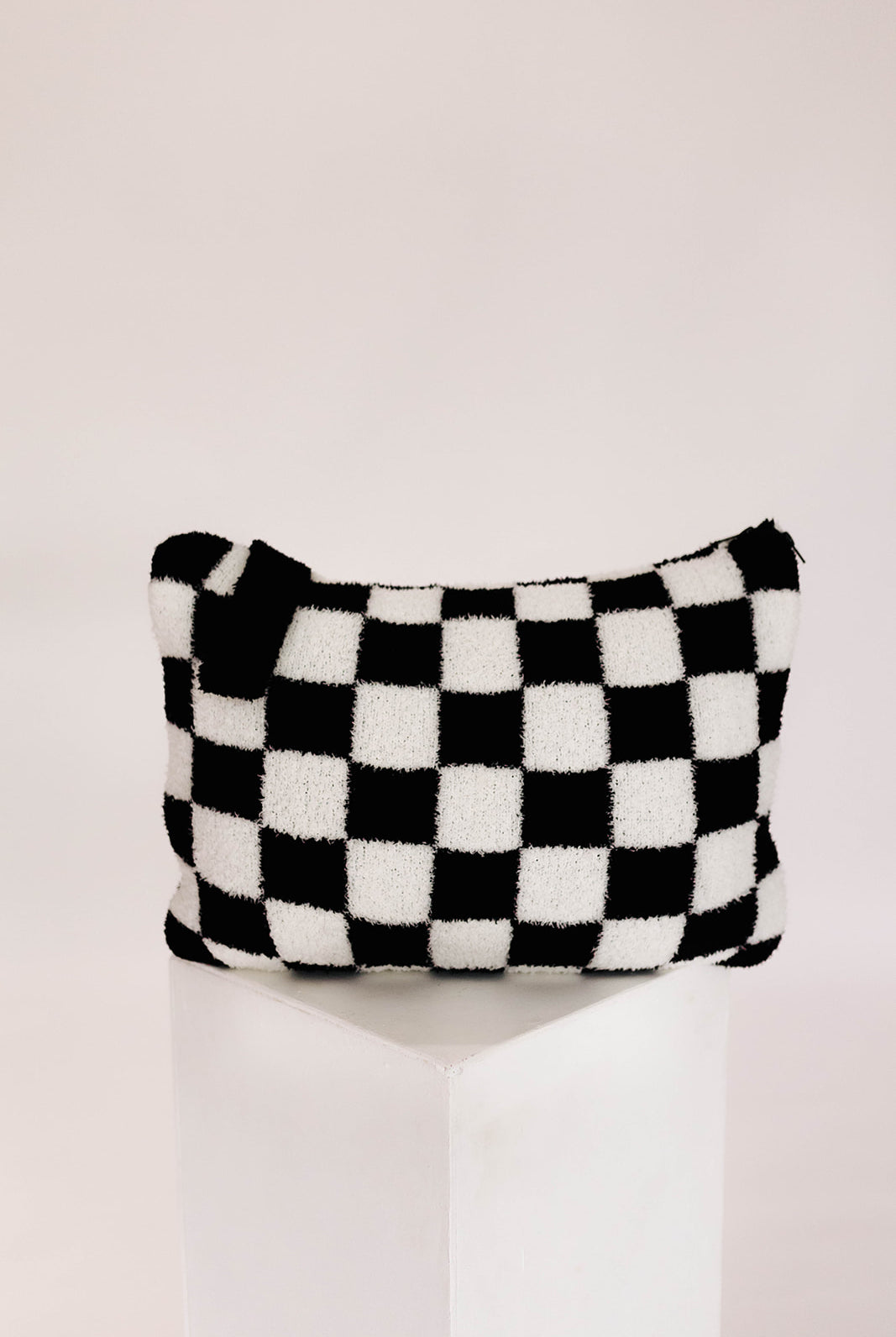 Black and white checkered pillow on a white background