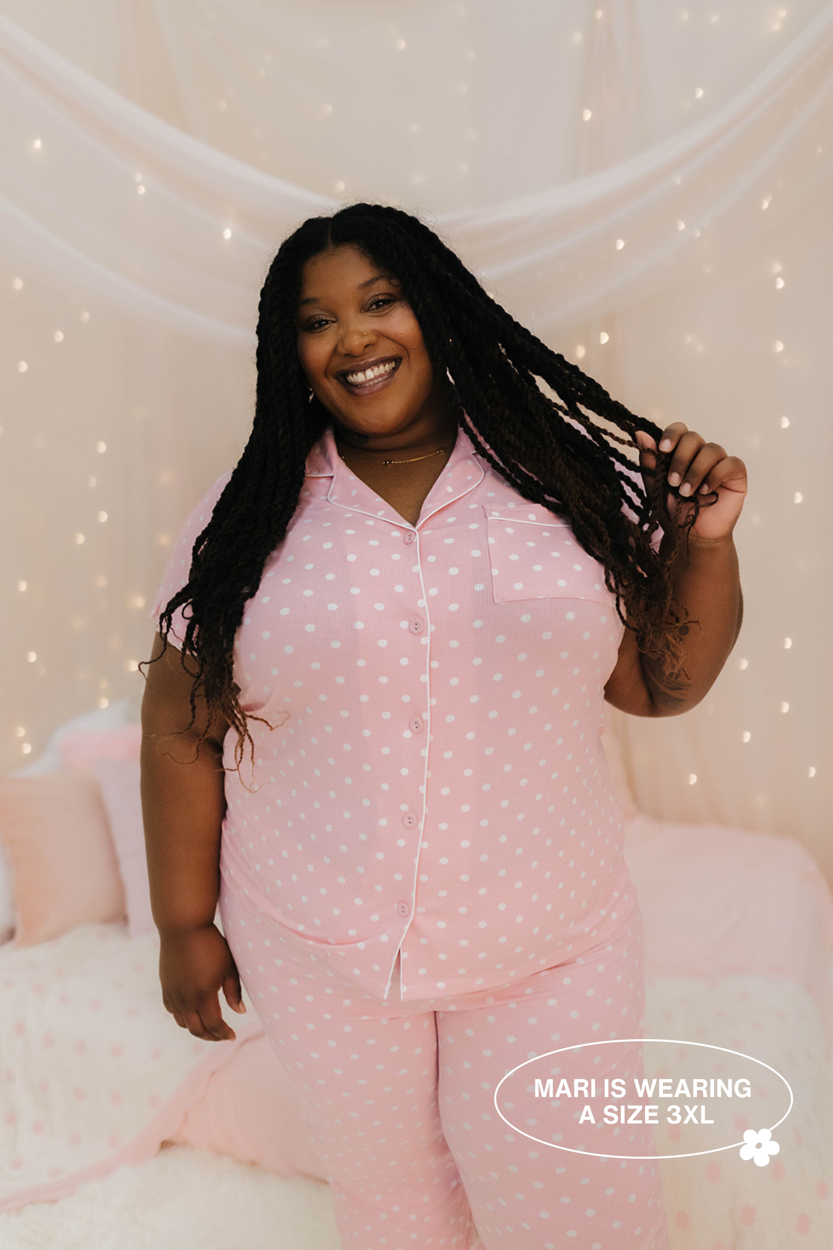 Woman wearing pink polka dot pajamas against a softly lit background