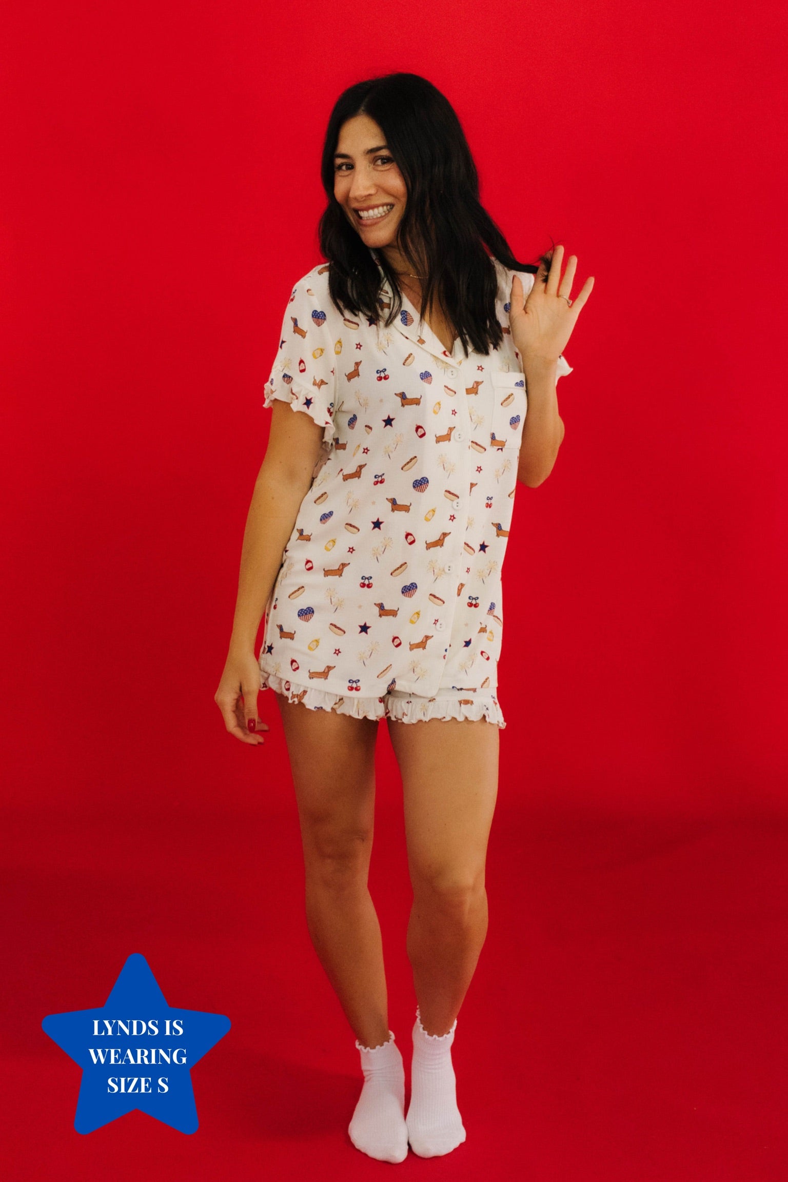 Woman wearing a 4th of july patterned pajama set on a red background