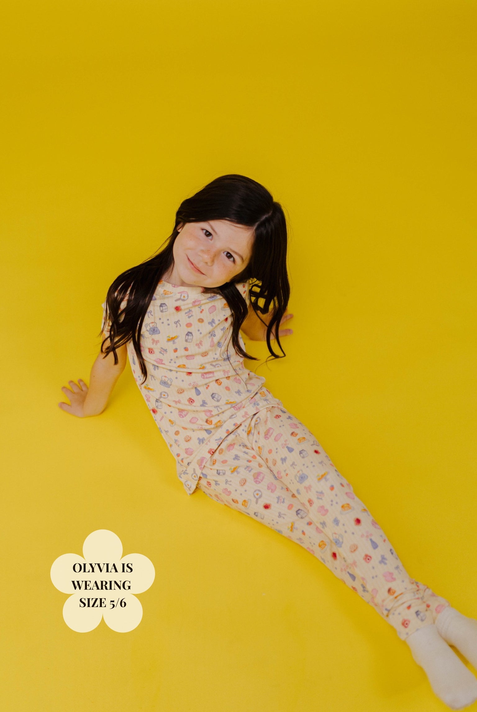 Young girl wearing a brunch pj set on a yellow background