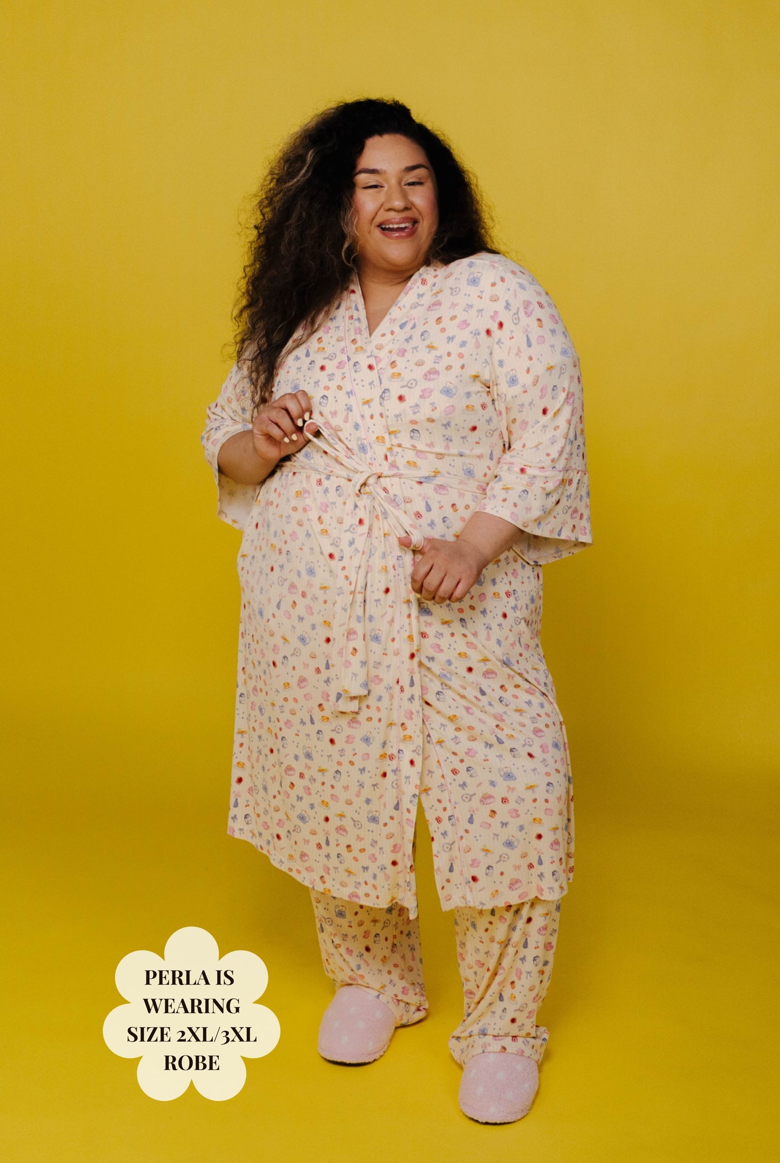 Woman wearing a brunch robe and pajama pants on a yellow background