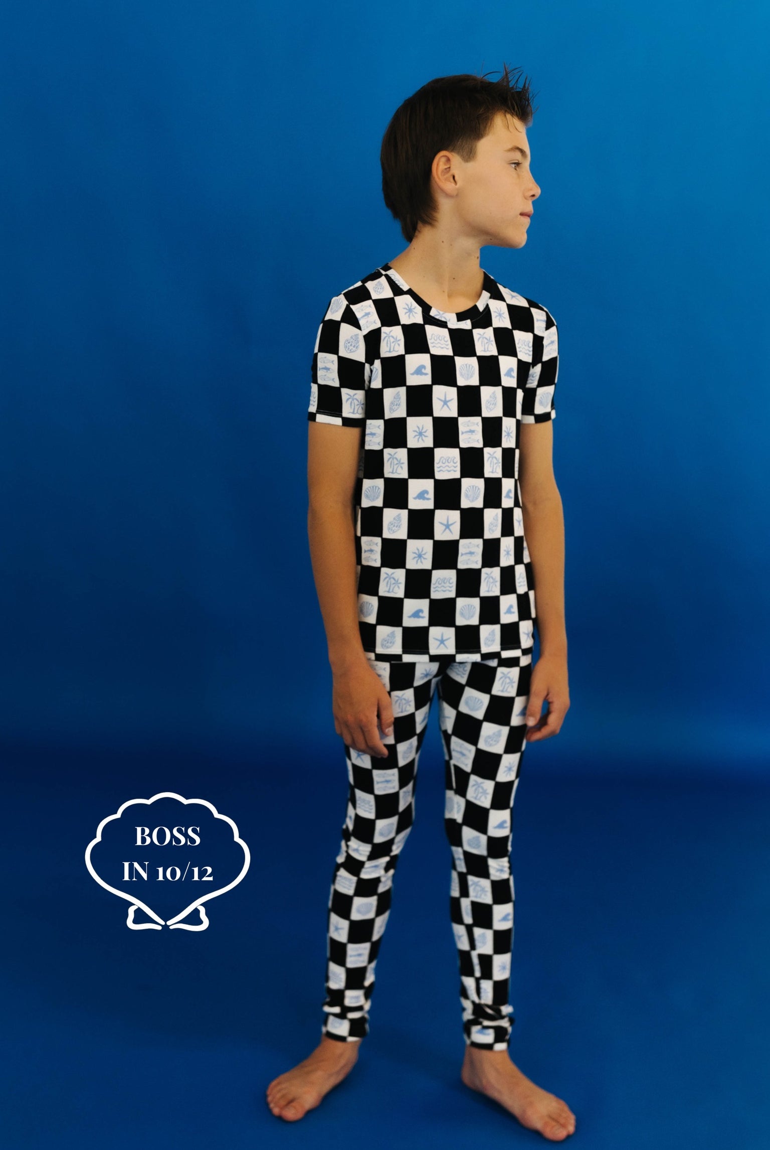 Child wearing a black and white checkered pj set on a blue background size 10/12