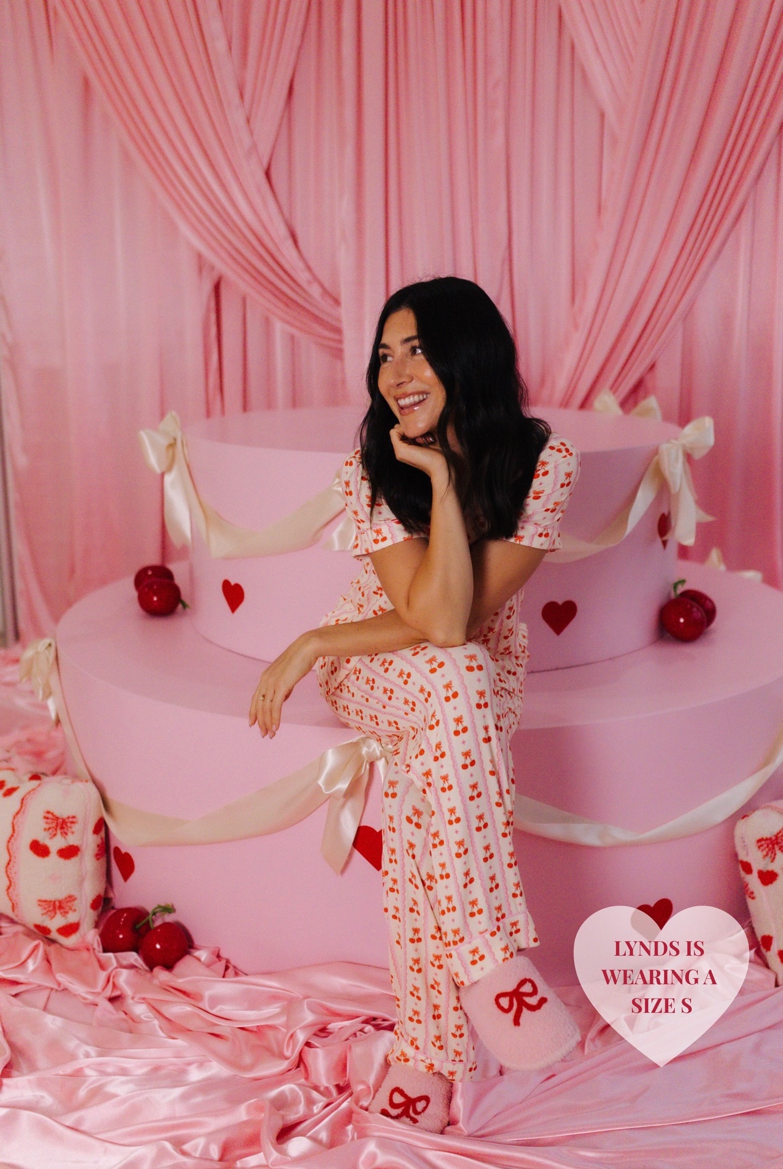 Lynds sitting on the cake smiling and looking to the side