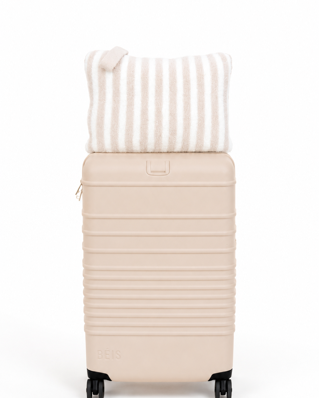 Beige suitcase with a striped pillow on a white background