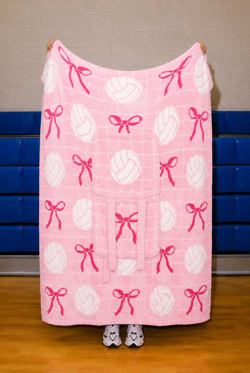pink quillow full blanket size with a white net in the background and volleyballs and bows