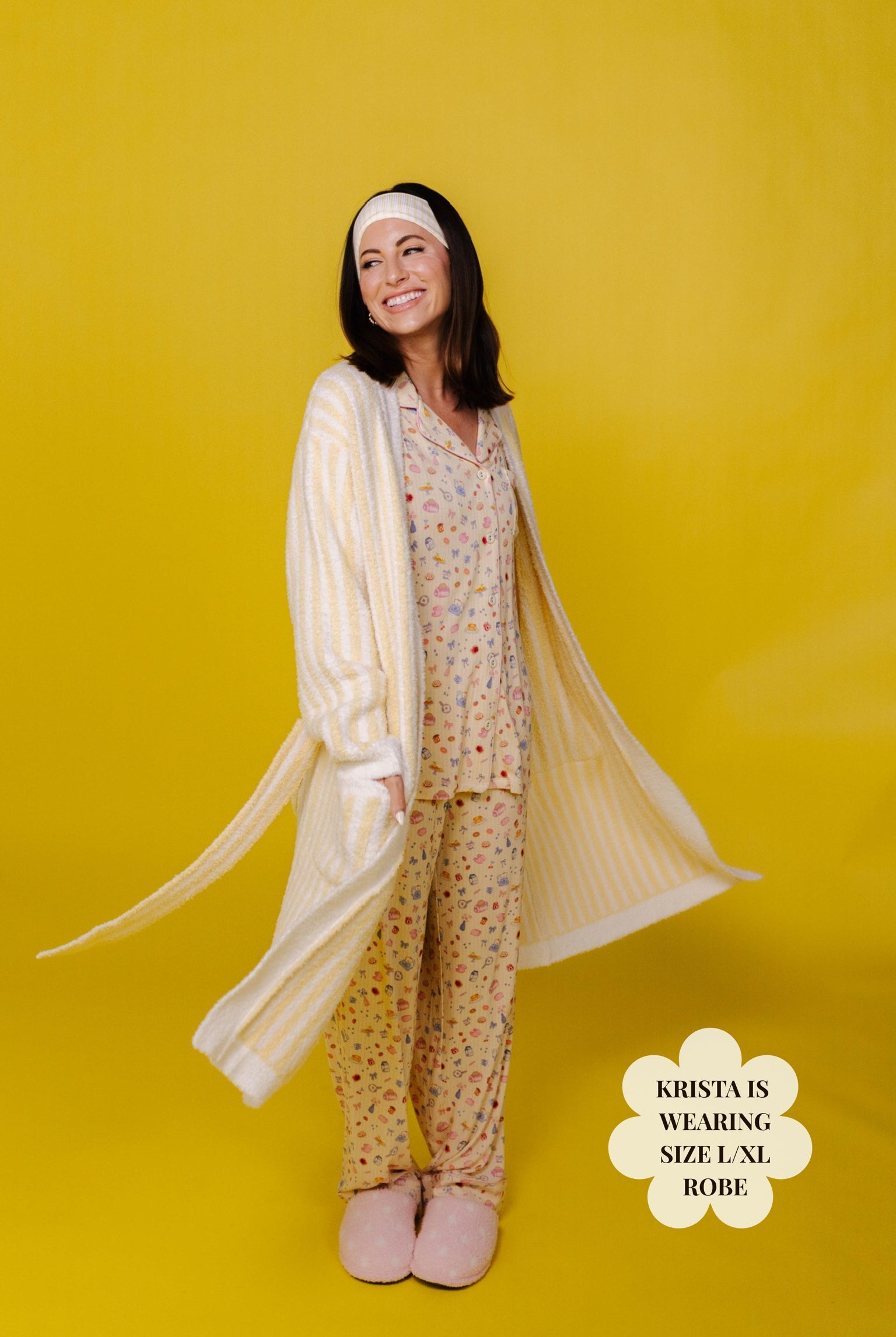 Woman wearing a matching pajama set with a long robe on a yellow background