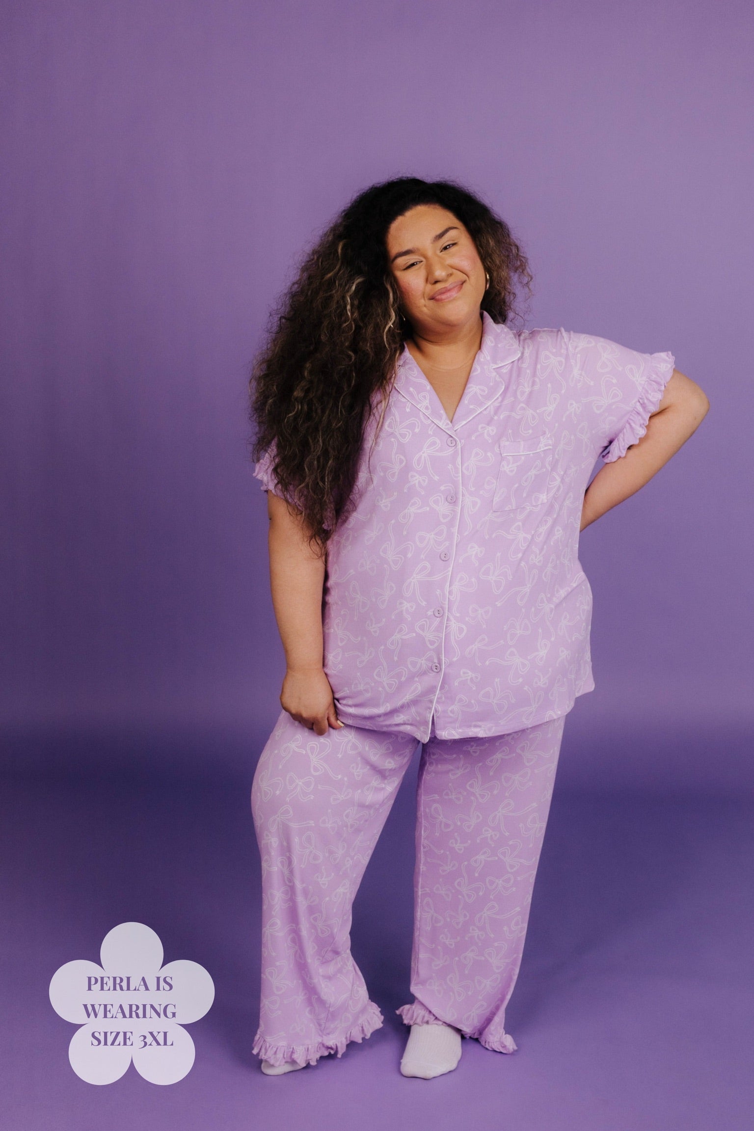Woman wearing a purple pajama set against a purple background