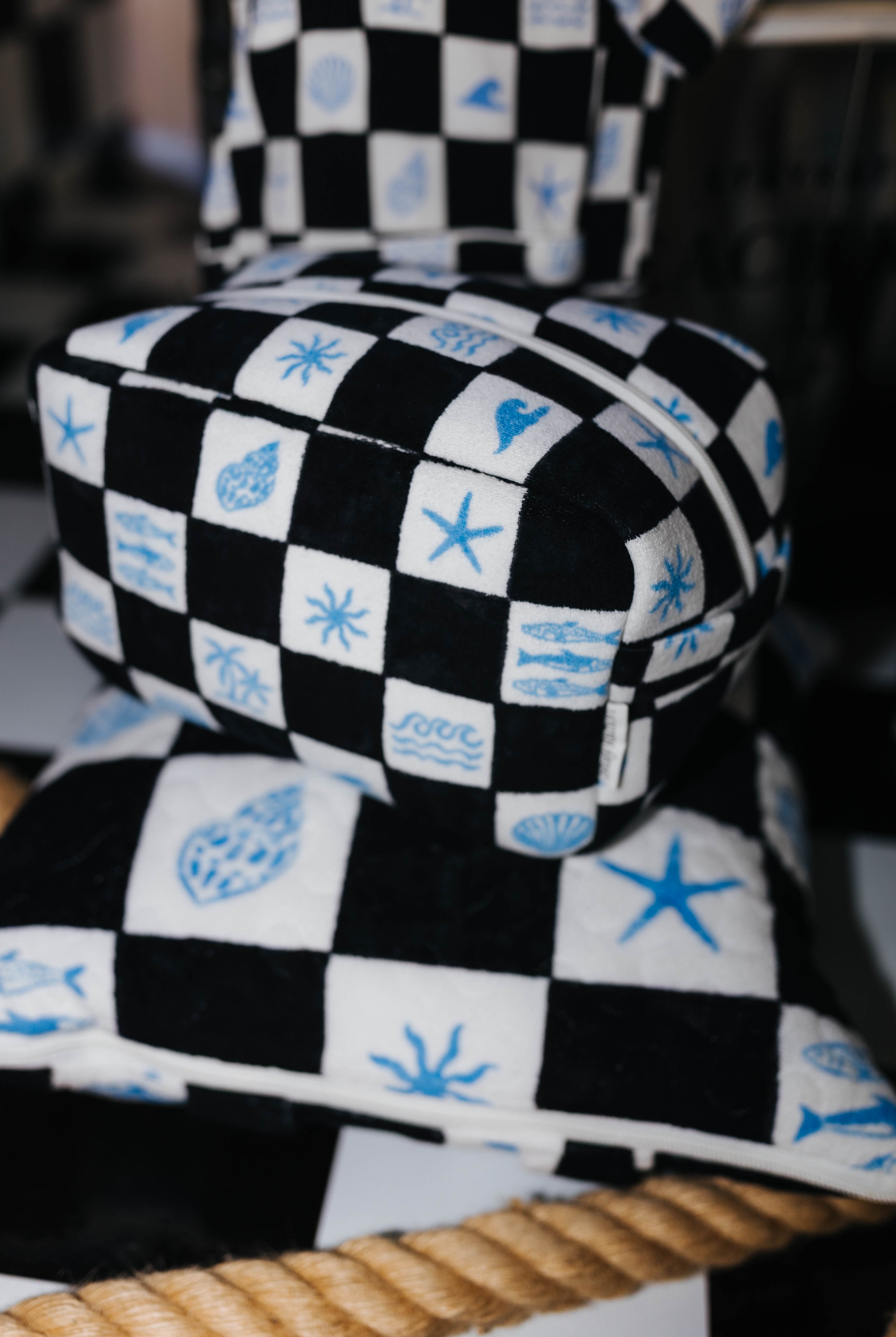 Checkered cosmetic bag on top of checkered picnic quillow