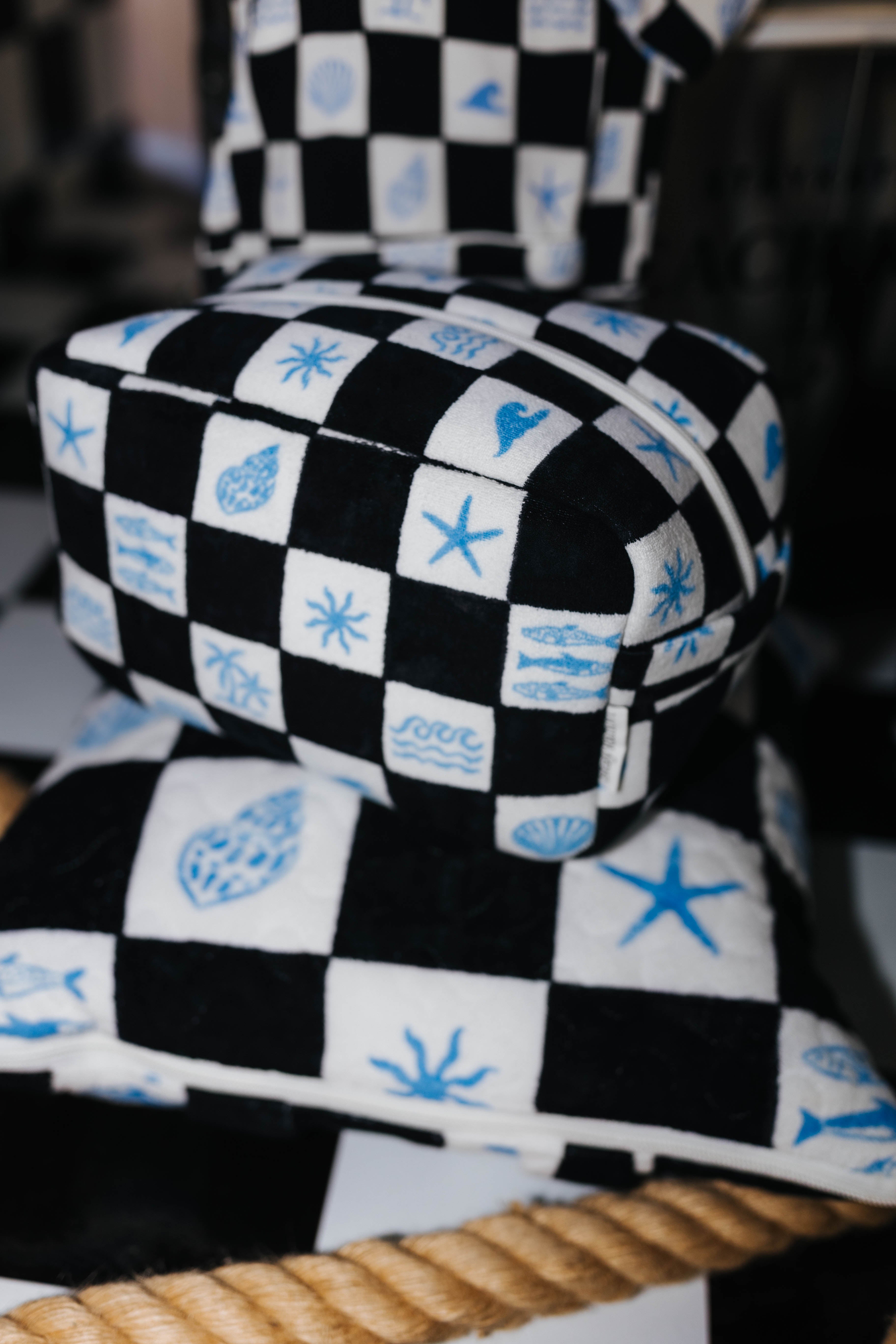Checkered cosmetic bag on top of checkered picnic quillow