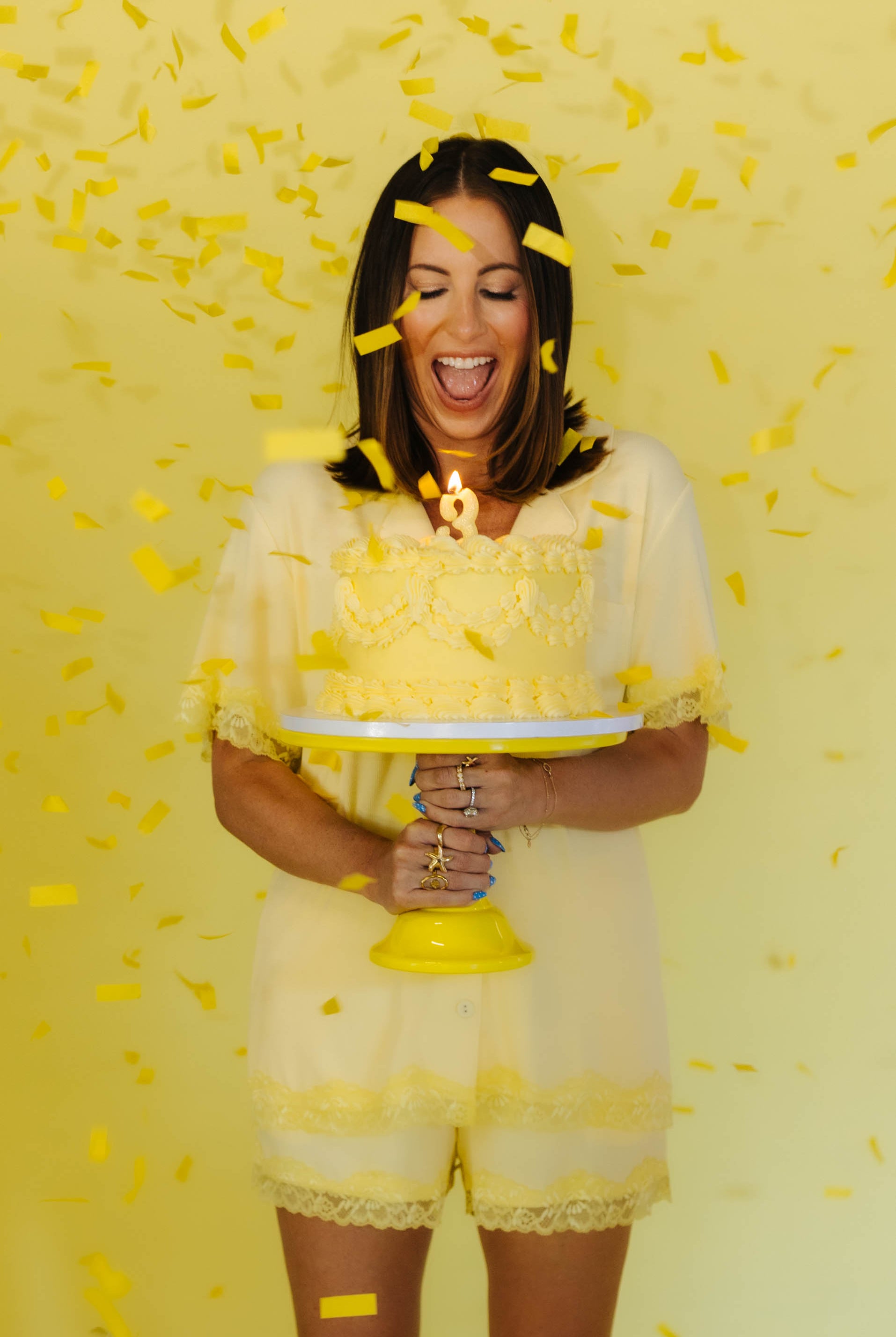 Krista holding a cake with confetti around her