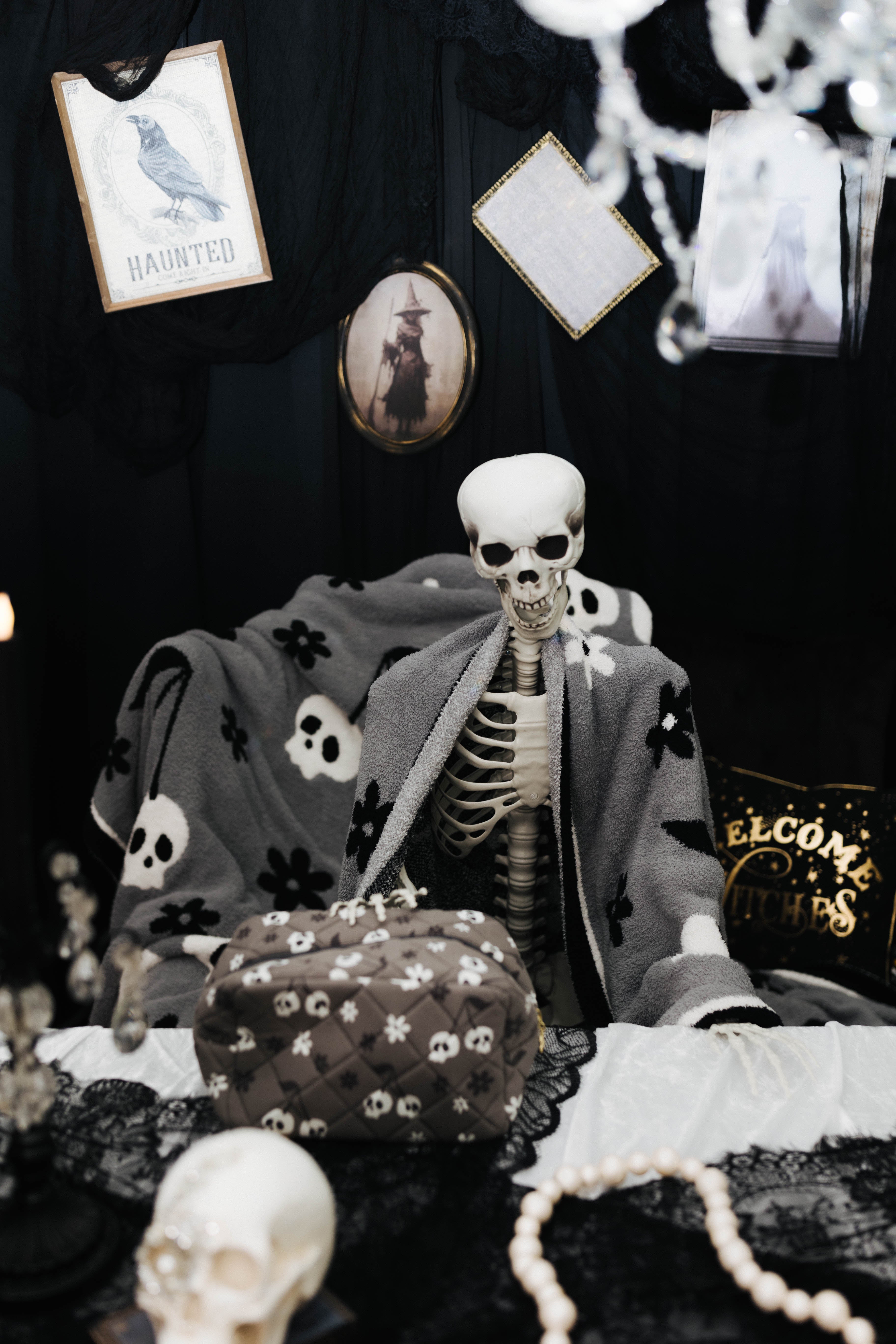 skelly cosmetic bag sitting on table with spooky decorations in the background
