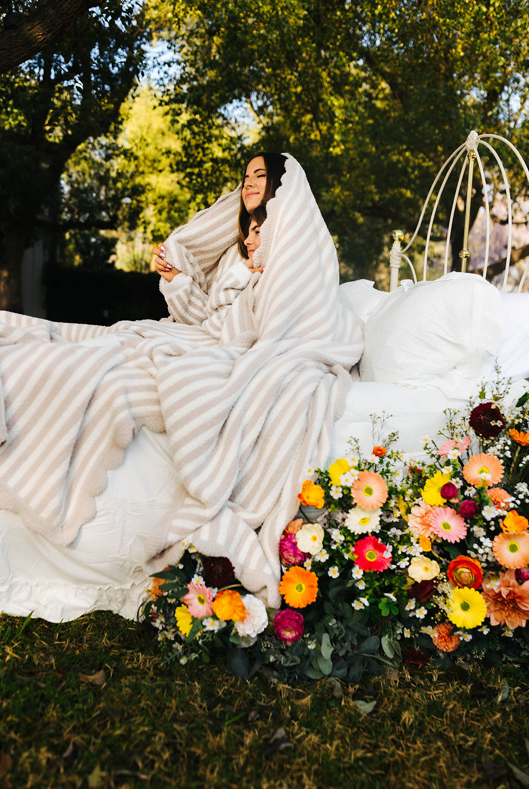 wrapped in the sand pinstripe blanket on the bed posing