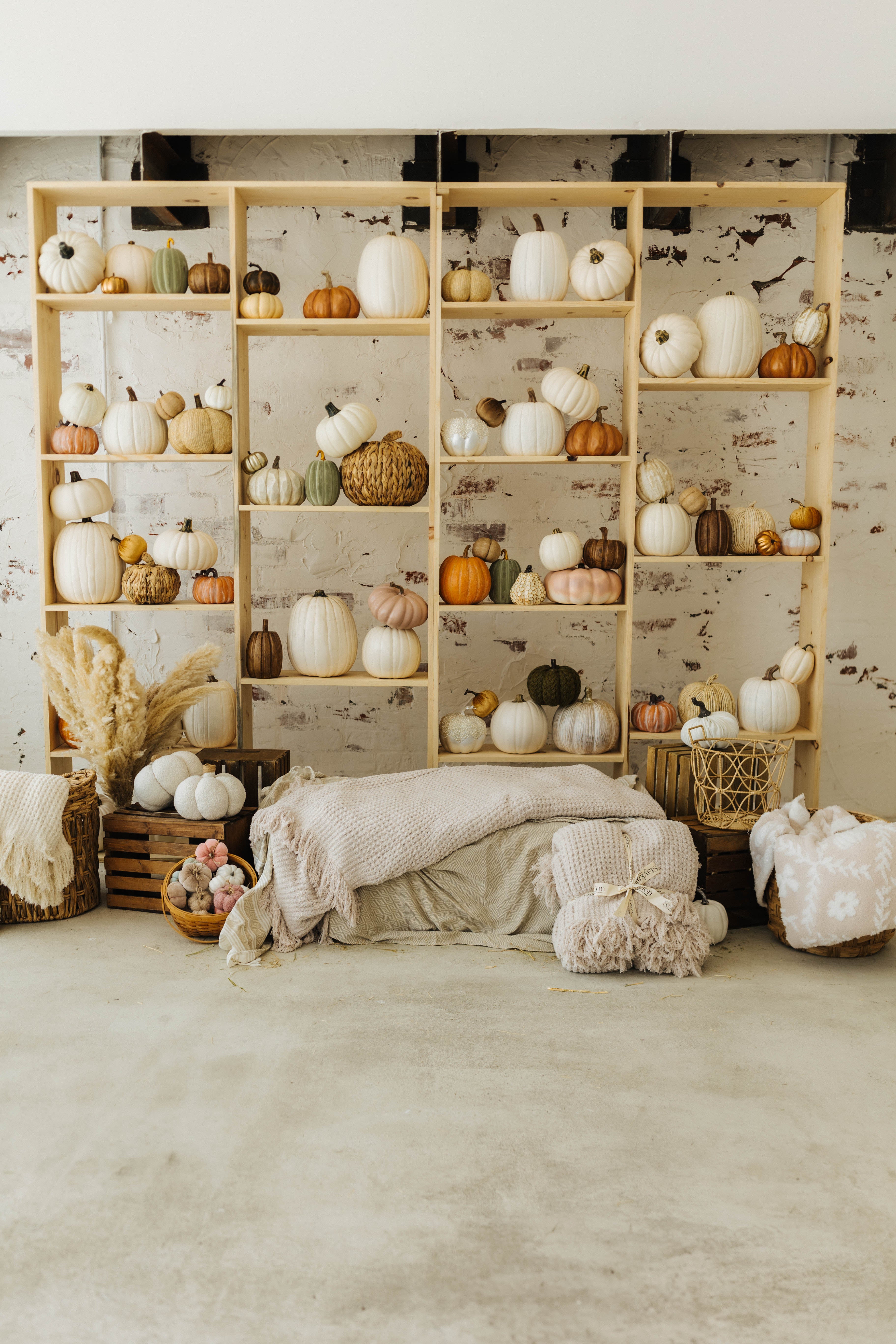 both cream and sand waffle blankets laying on hay and in a basket with pumpkin decorations in the background