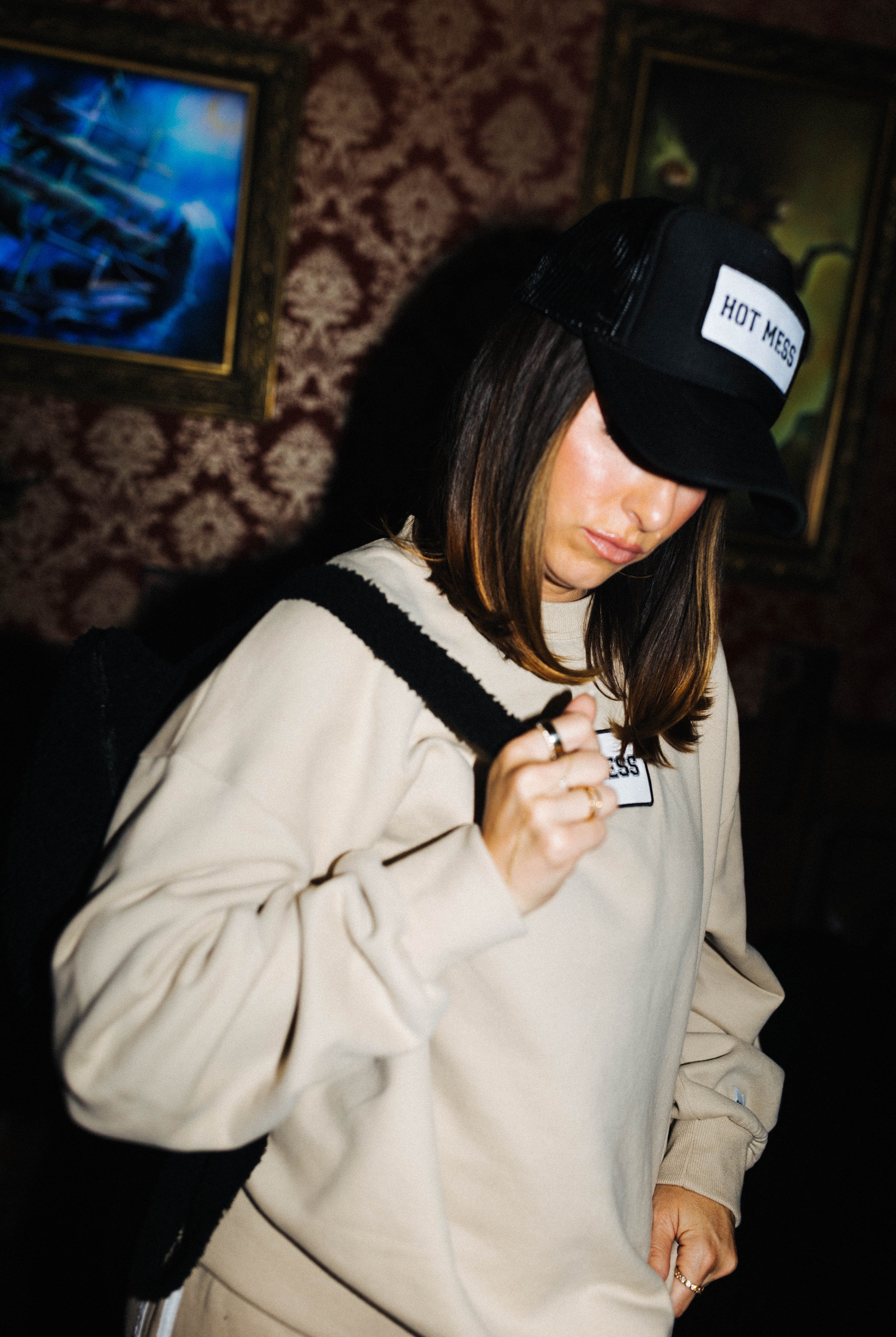 Black Hot Mess hat styled with a matching patch sweatshirt