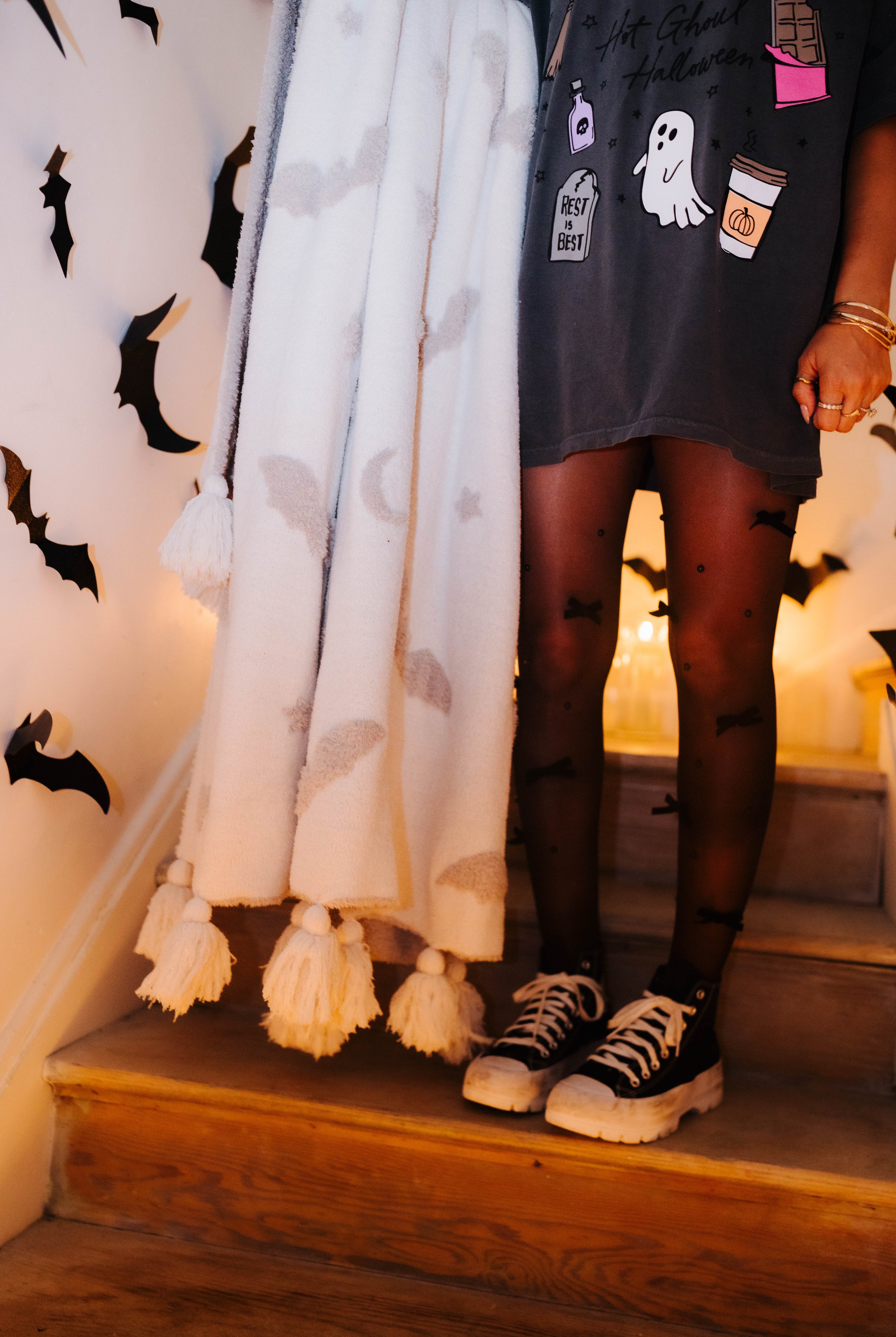 model wearing hot ghoul tee and tights with converse holding the bat blanket showing the tassels