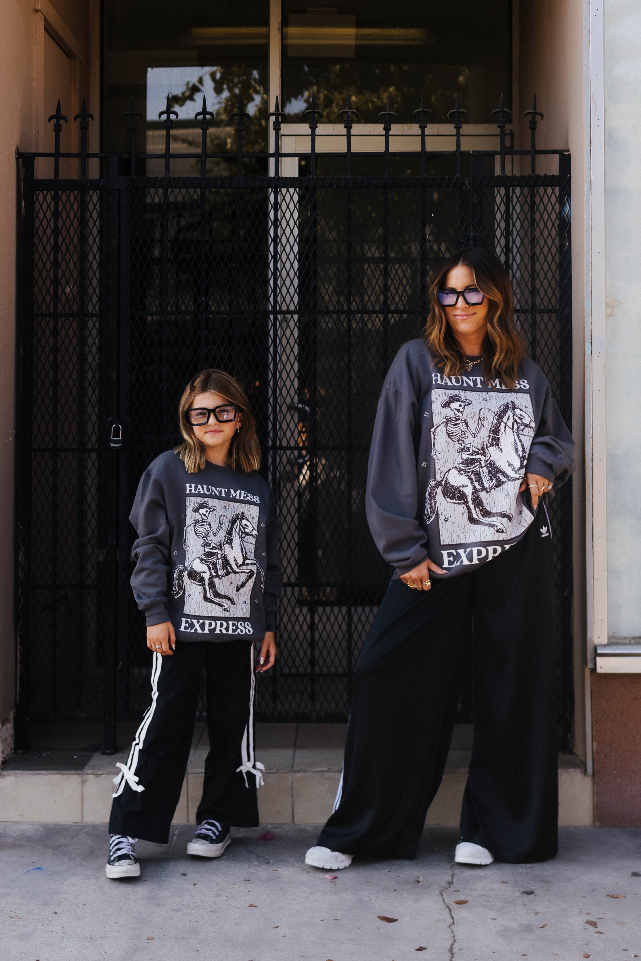 models wearing haunt mess express sweatshirts outside in the street