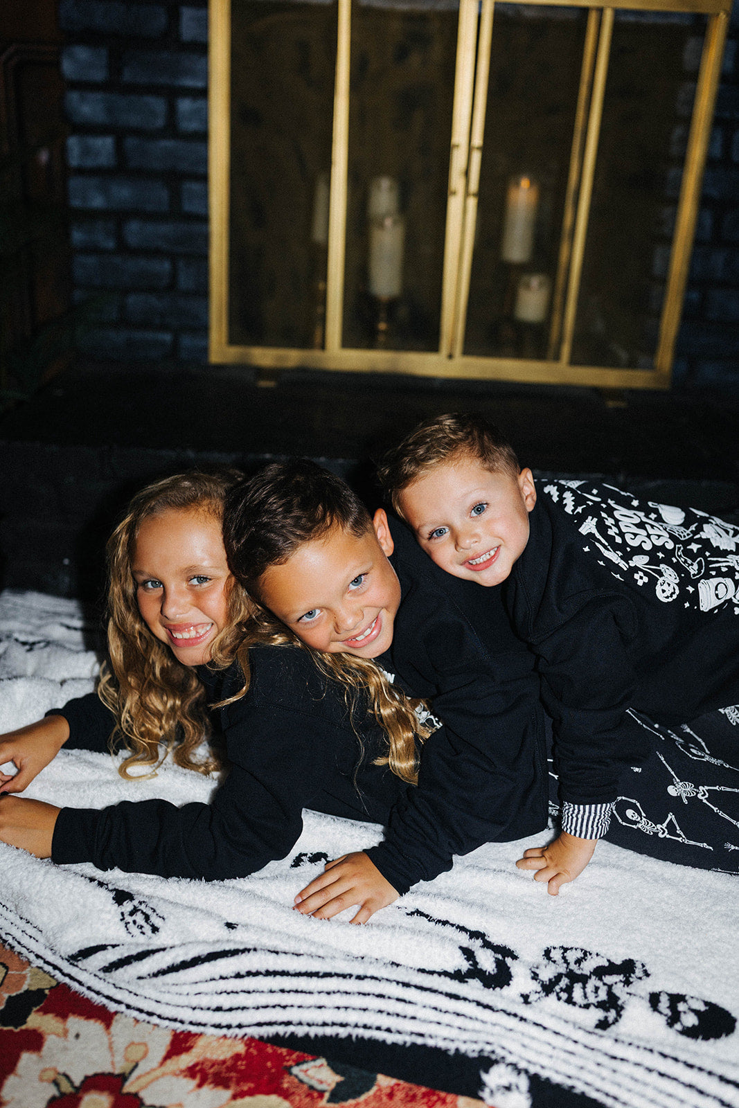 3 kids laying on top of eachother in matching outfits