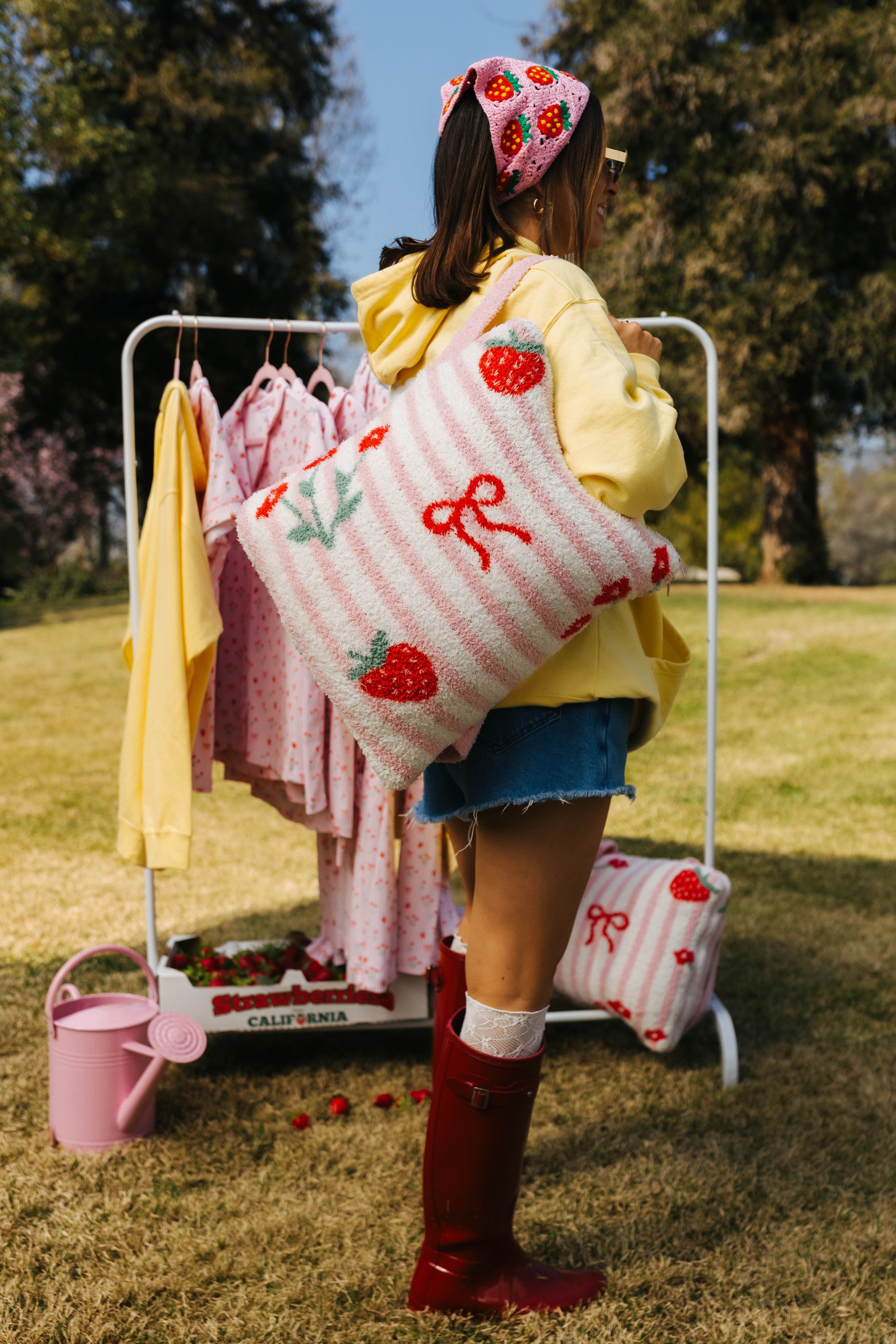 Krista holding a pink and white patterned quillow with red bows outdoors