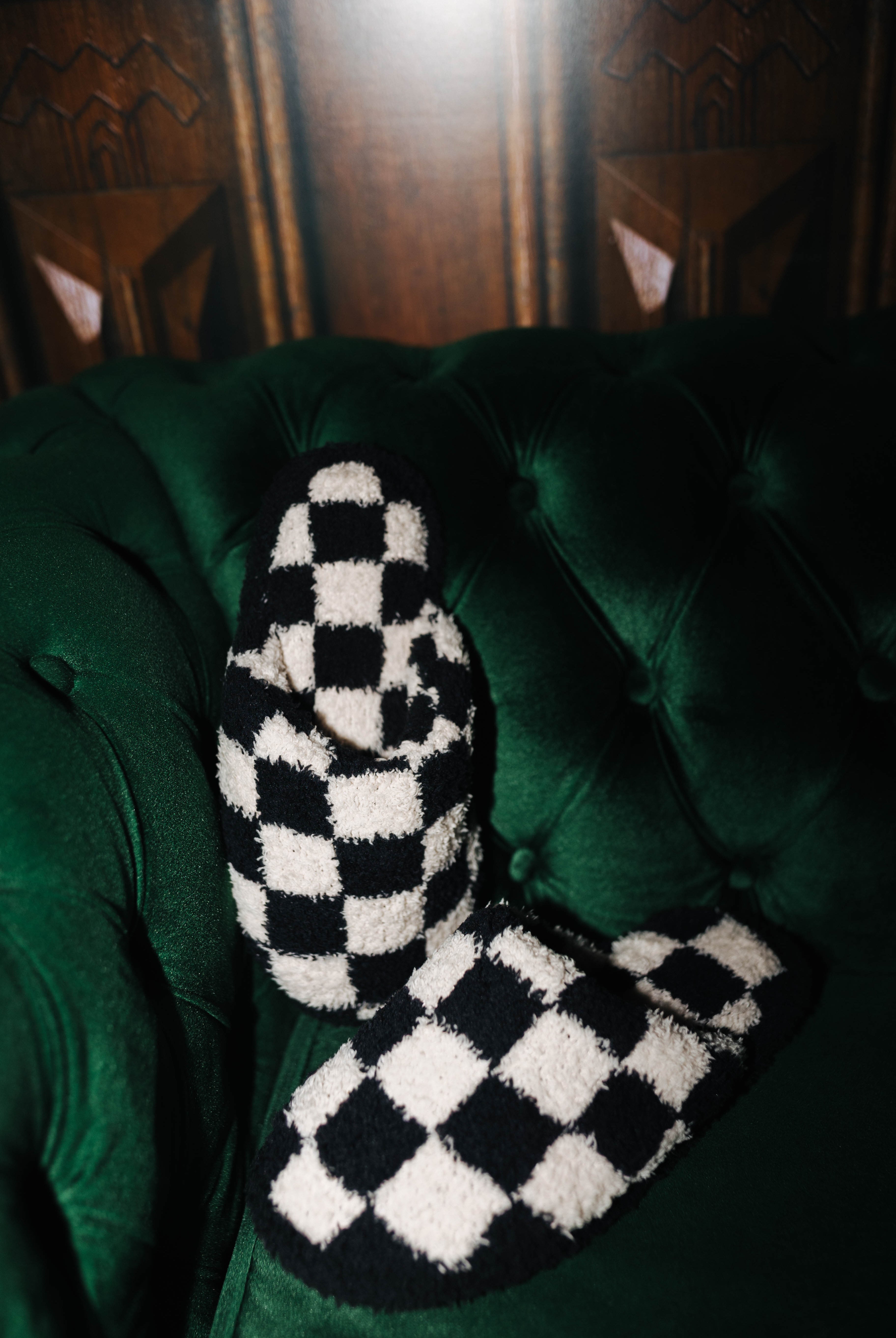 Sand and black check slippers arranged on a green chair