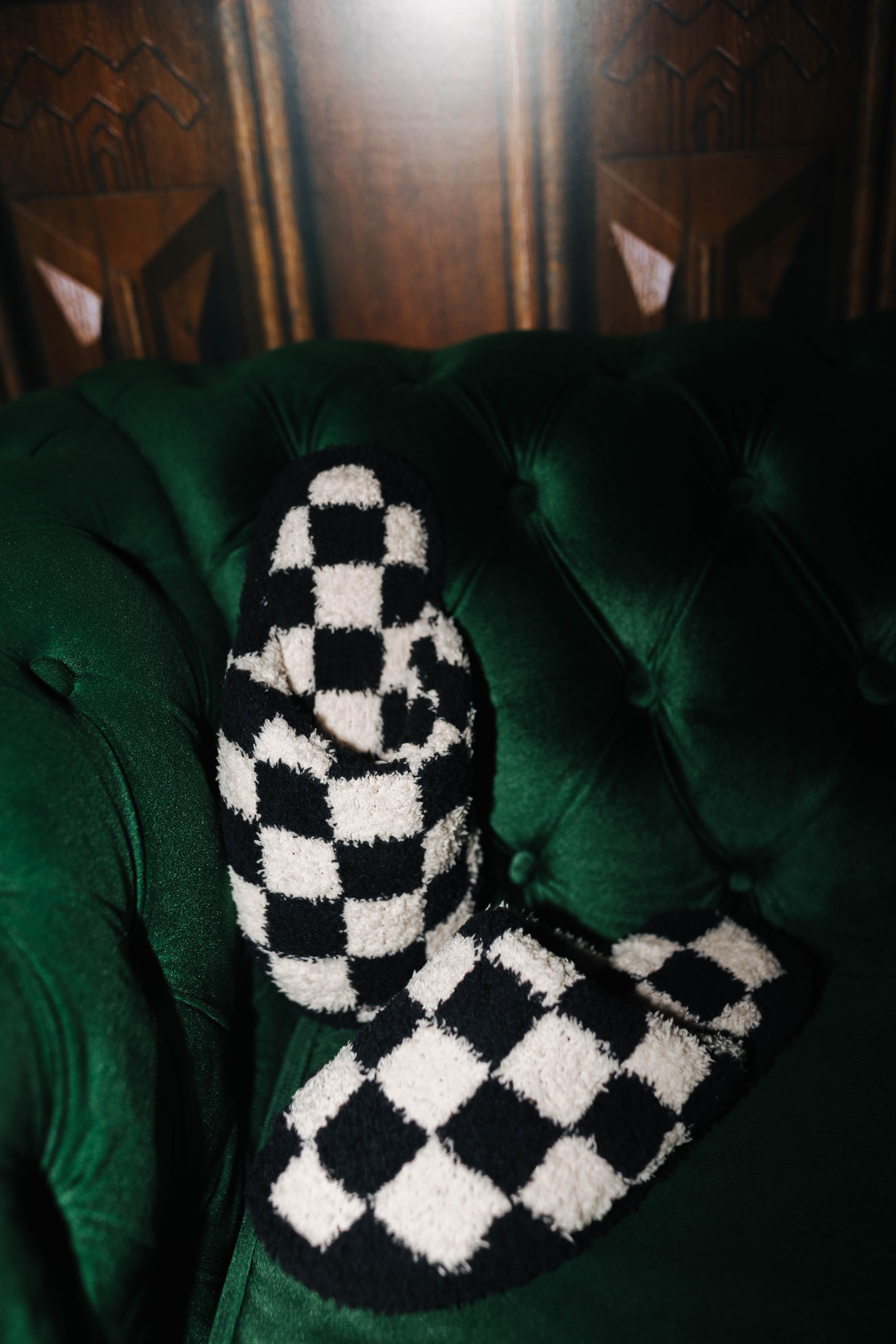 Sand and black check slippers arranged on a green chair