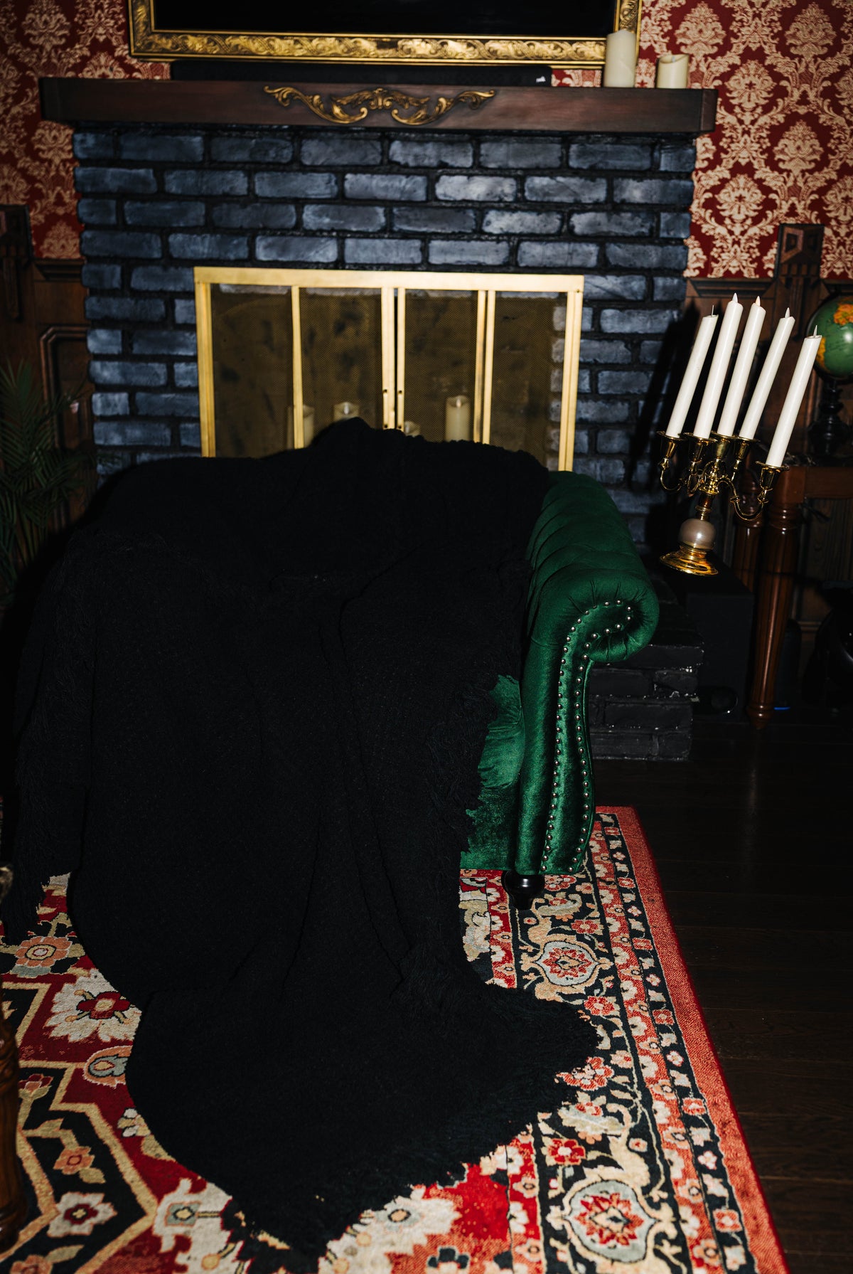 Black waffle fringe blanket draped over a green chair