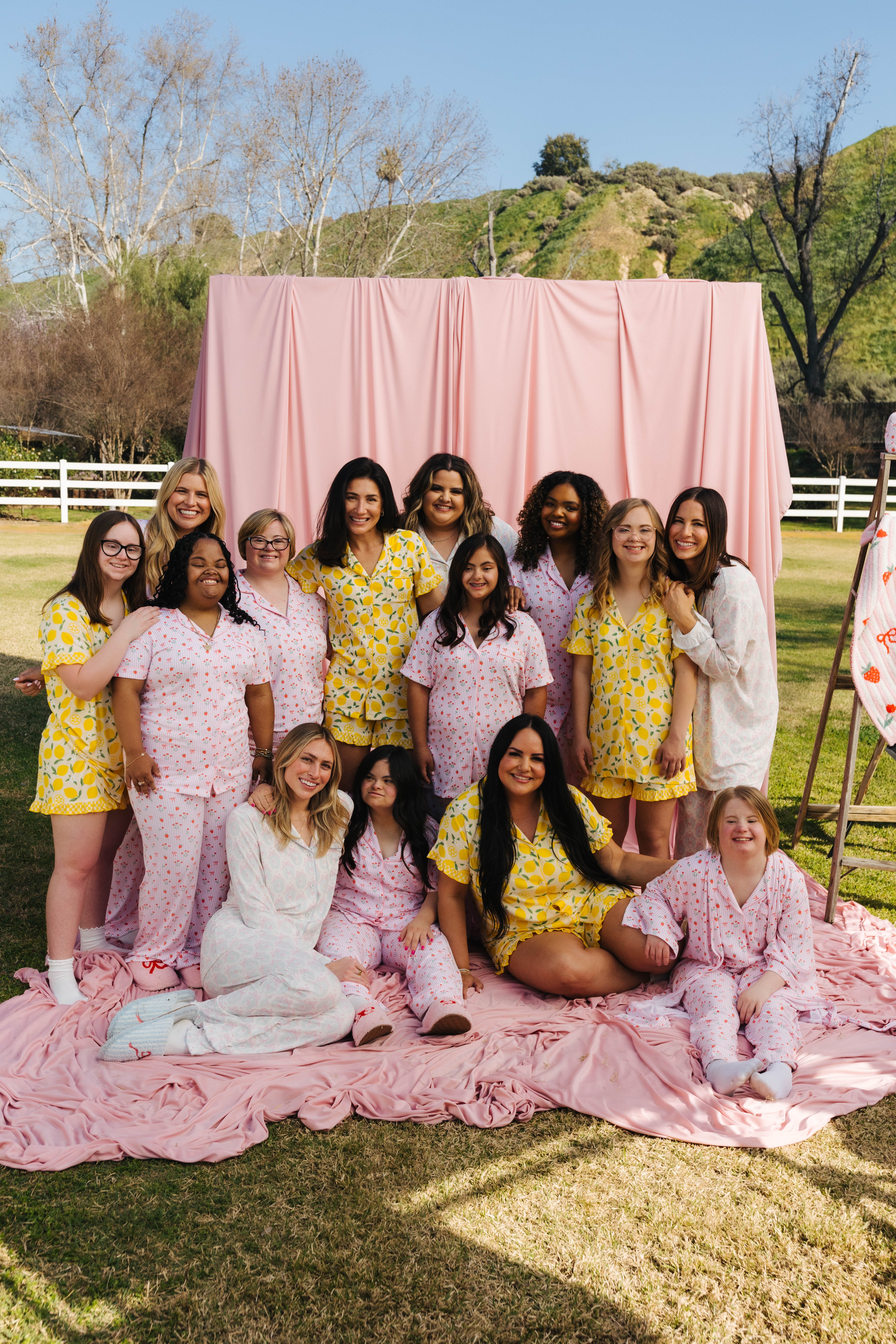 Group of women posing outdoors in the staykation sweet spring prints with a pink backdrop.
