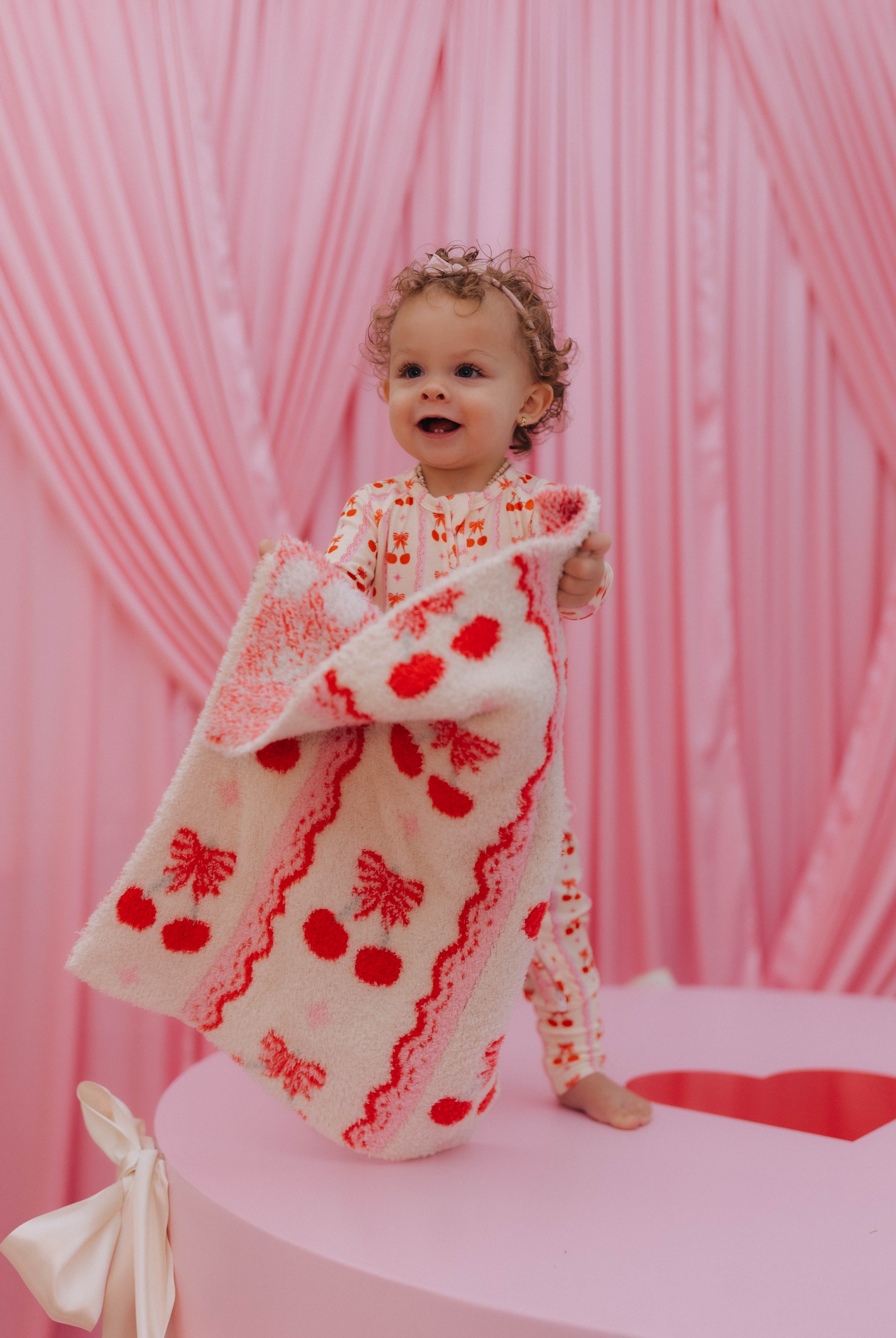 baby holding up the lovey blanket