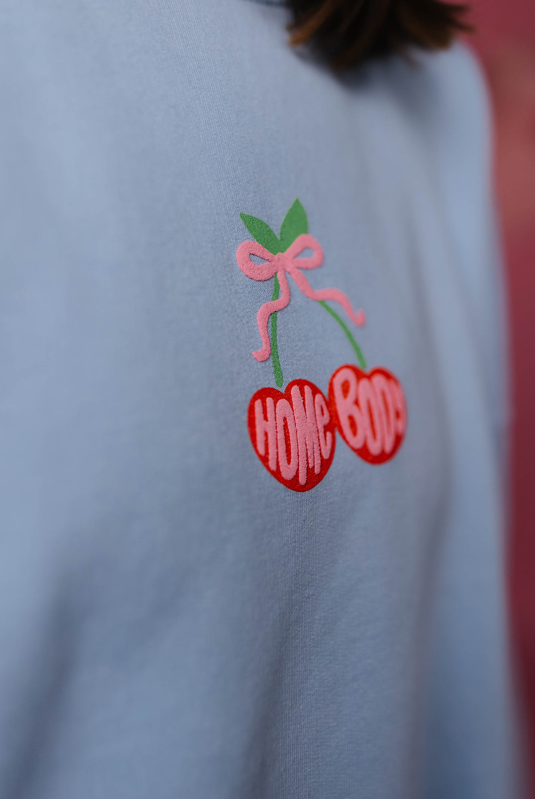 Puff fabric design on a light blue fabric with red cherries and pink bow.