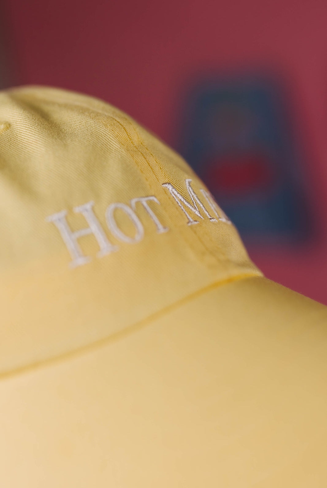 Yellow cap with 'HOT M' text on a blurred background