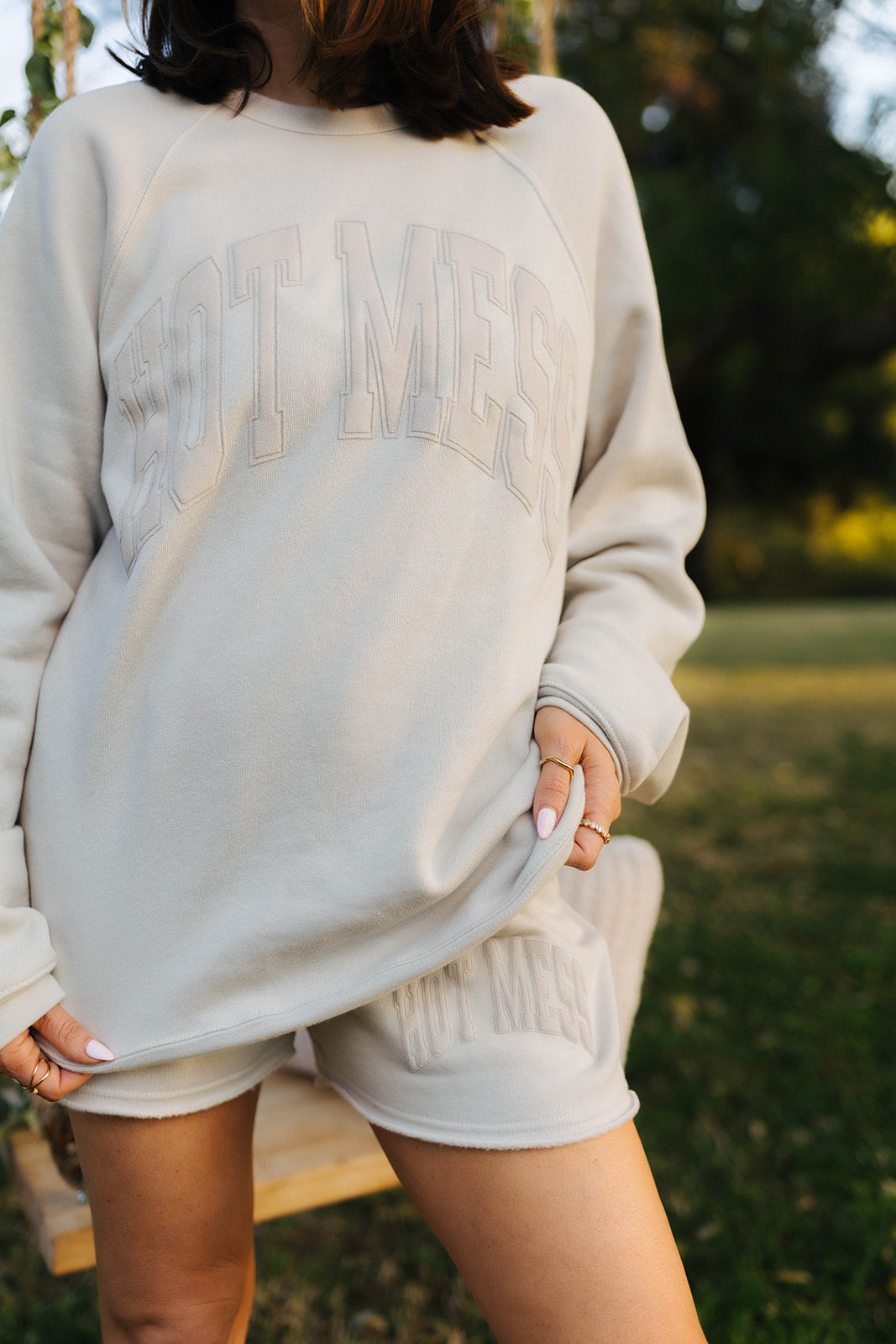 krista wearing the hot mess sweatshirt outside in a field