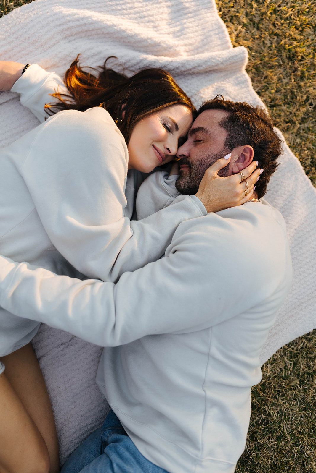 Couple lying on a blanket in a grassy field