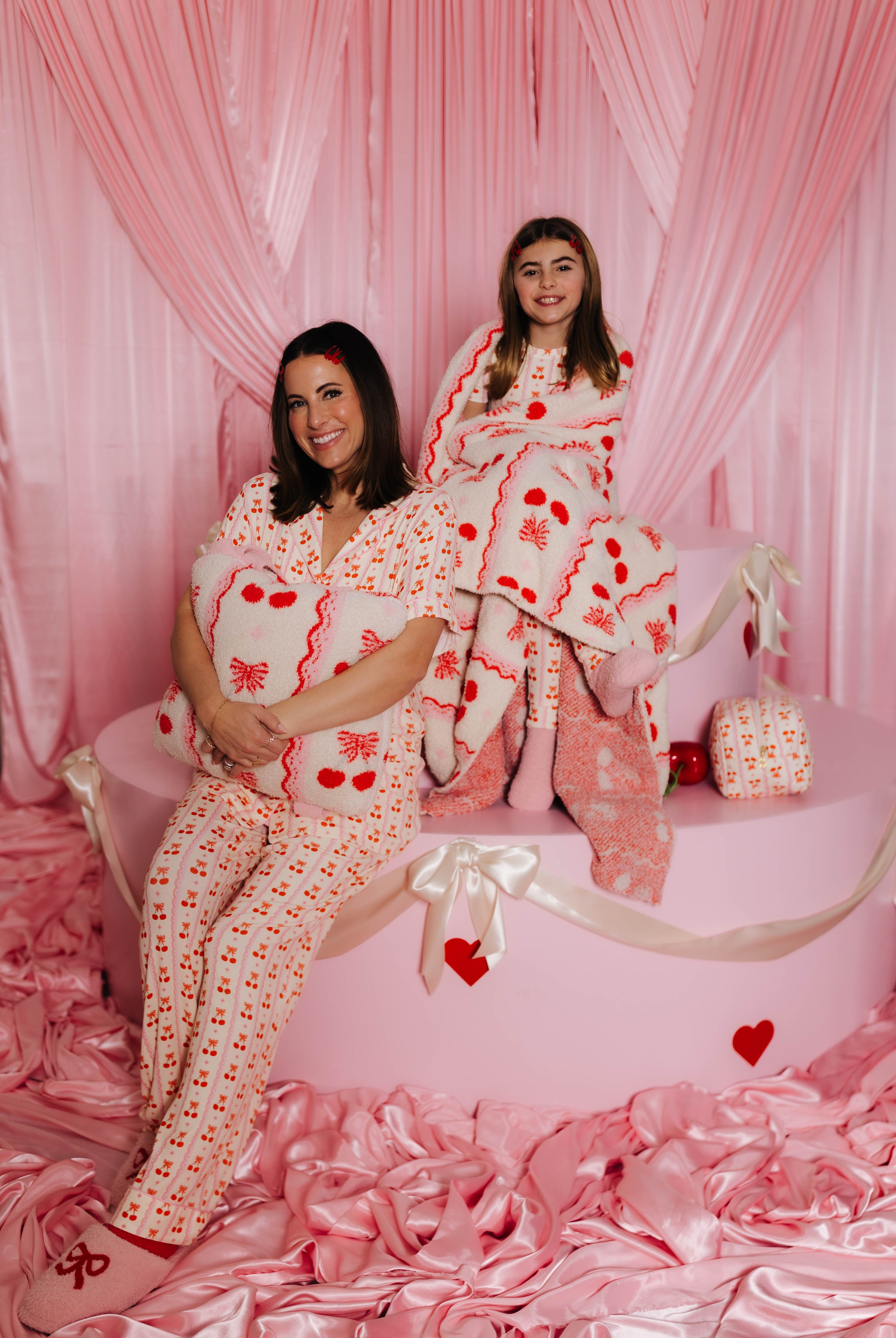 Krista and Kolly holding the quillow and wrapped in the quillow on the faux cake mold
