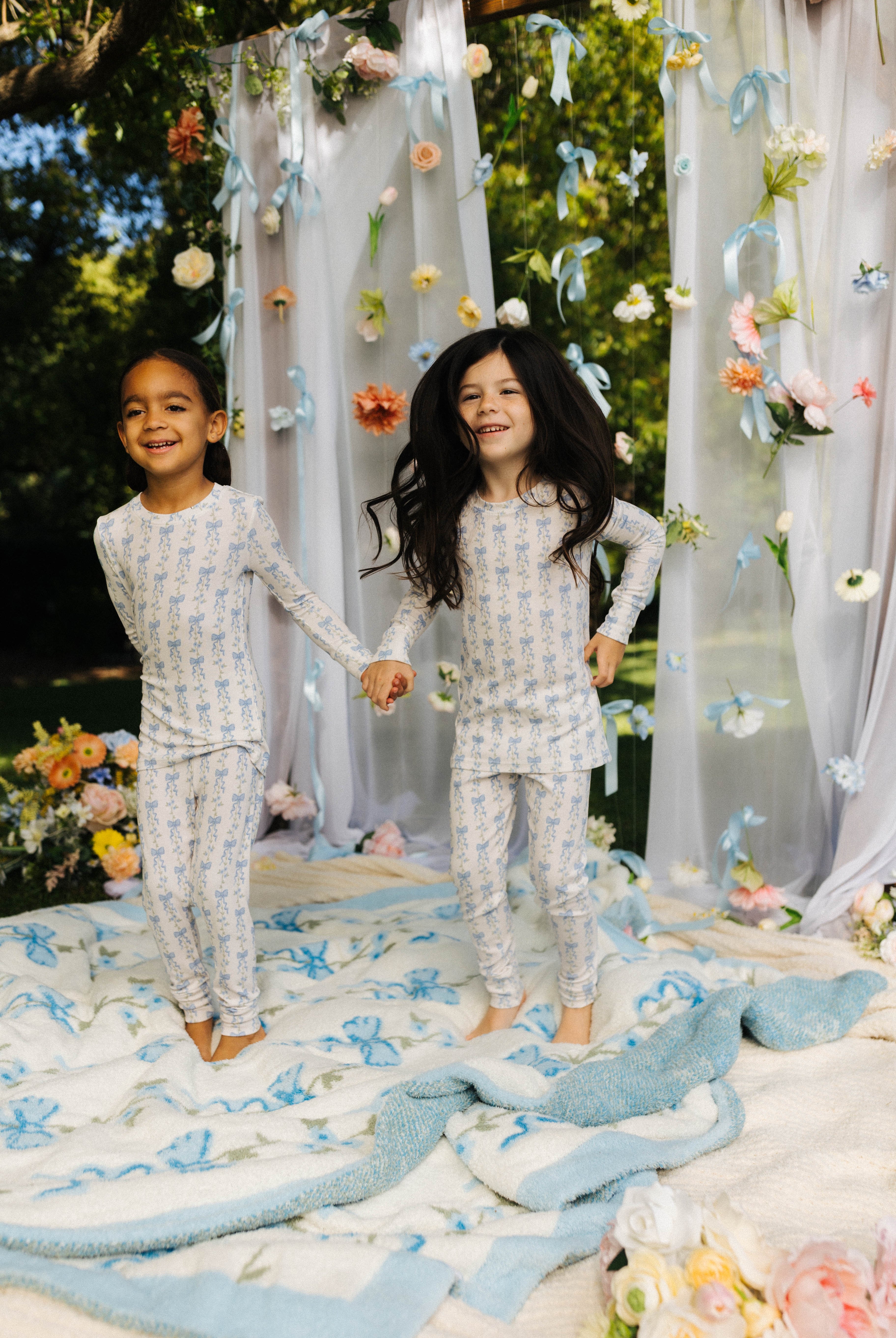 Two girls wearing the bow pjs on floral background