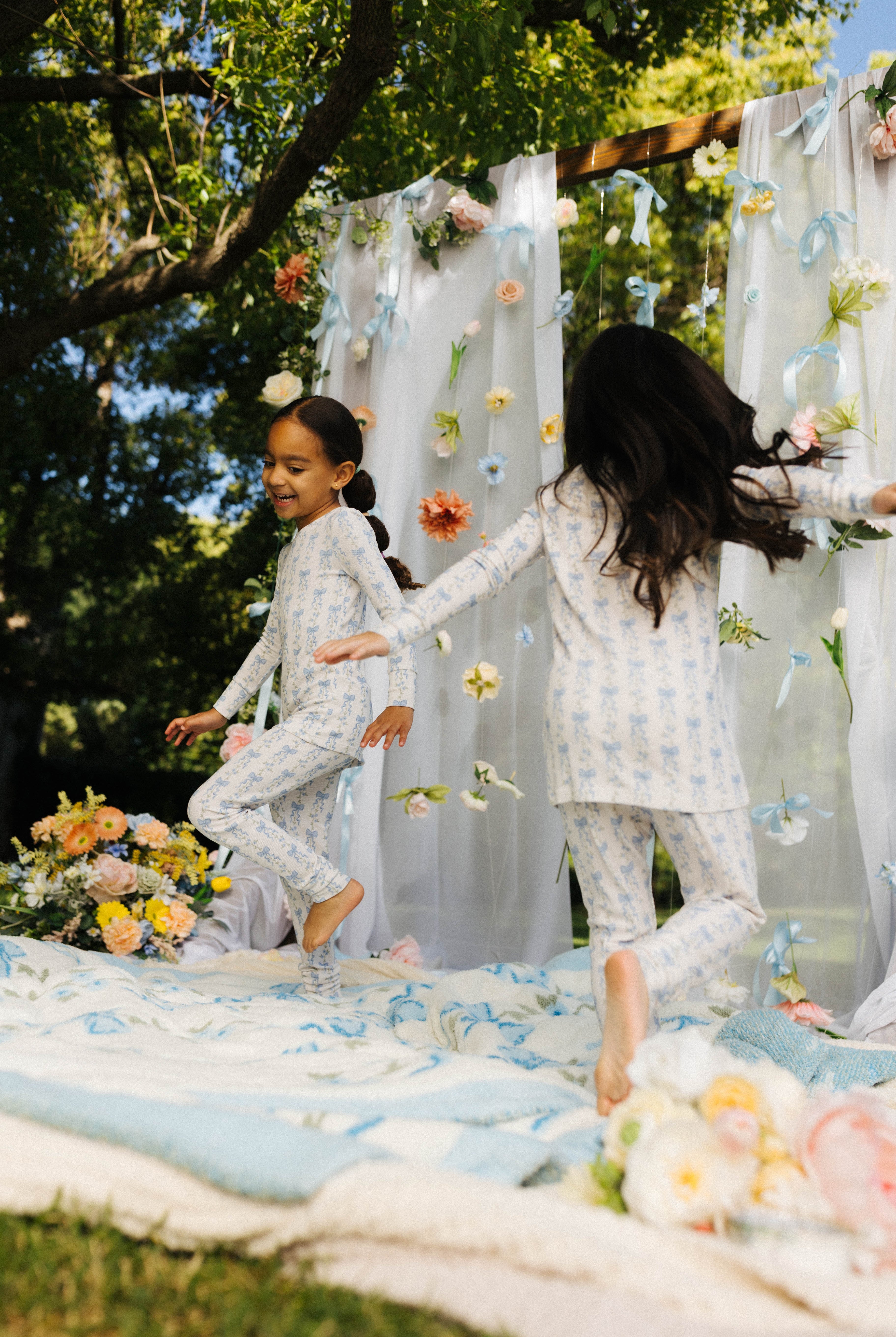 two children running around in the blue bow pj