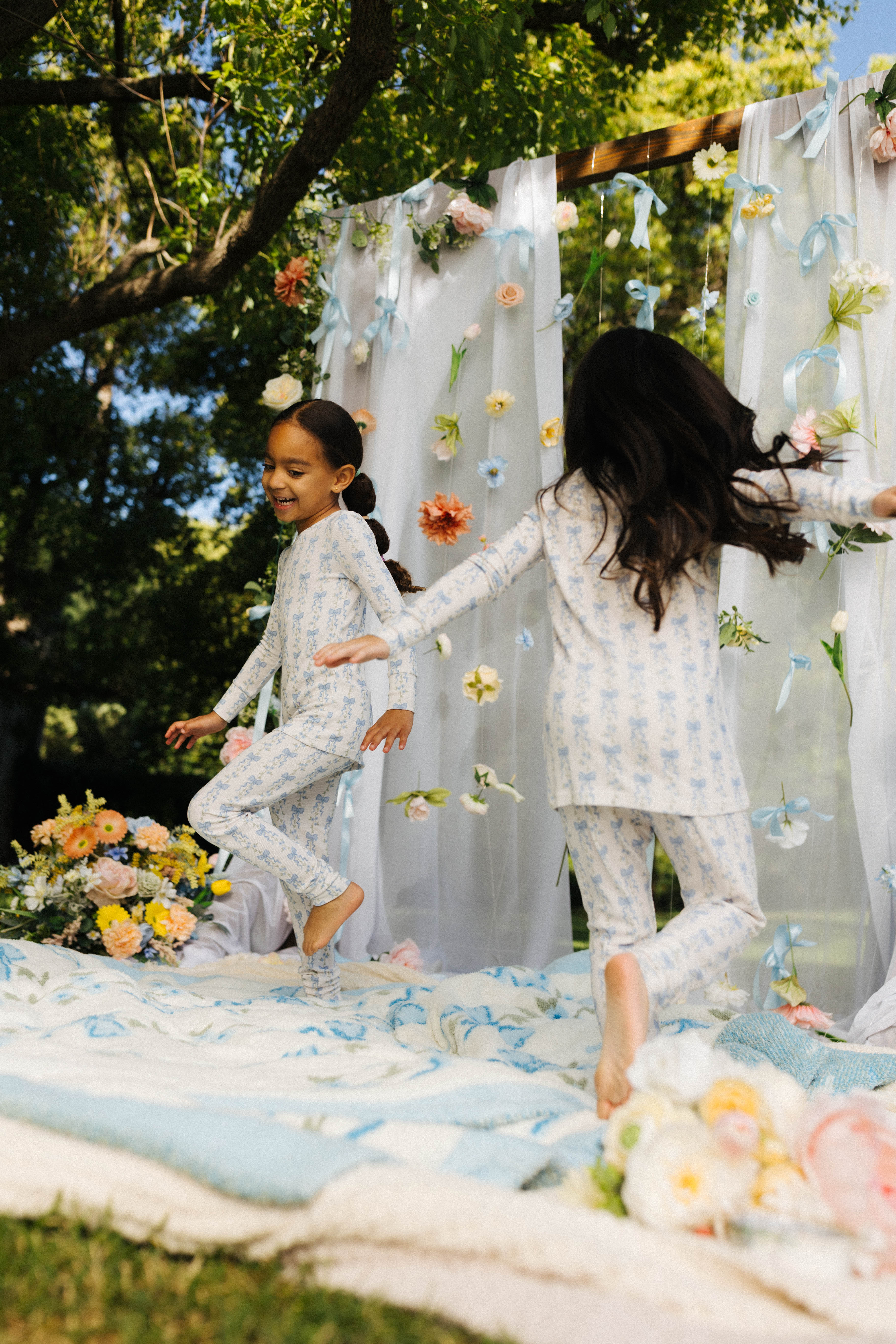 two children running around in the blue bow pj