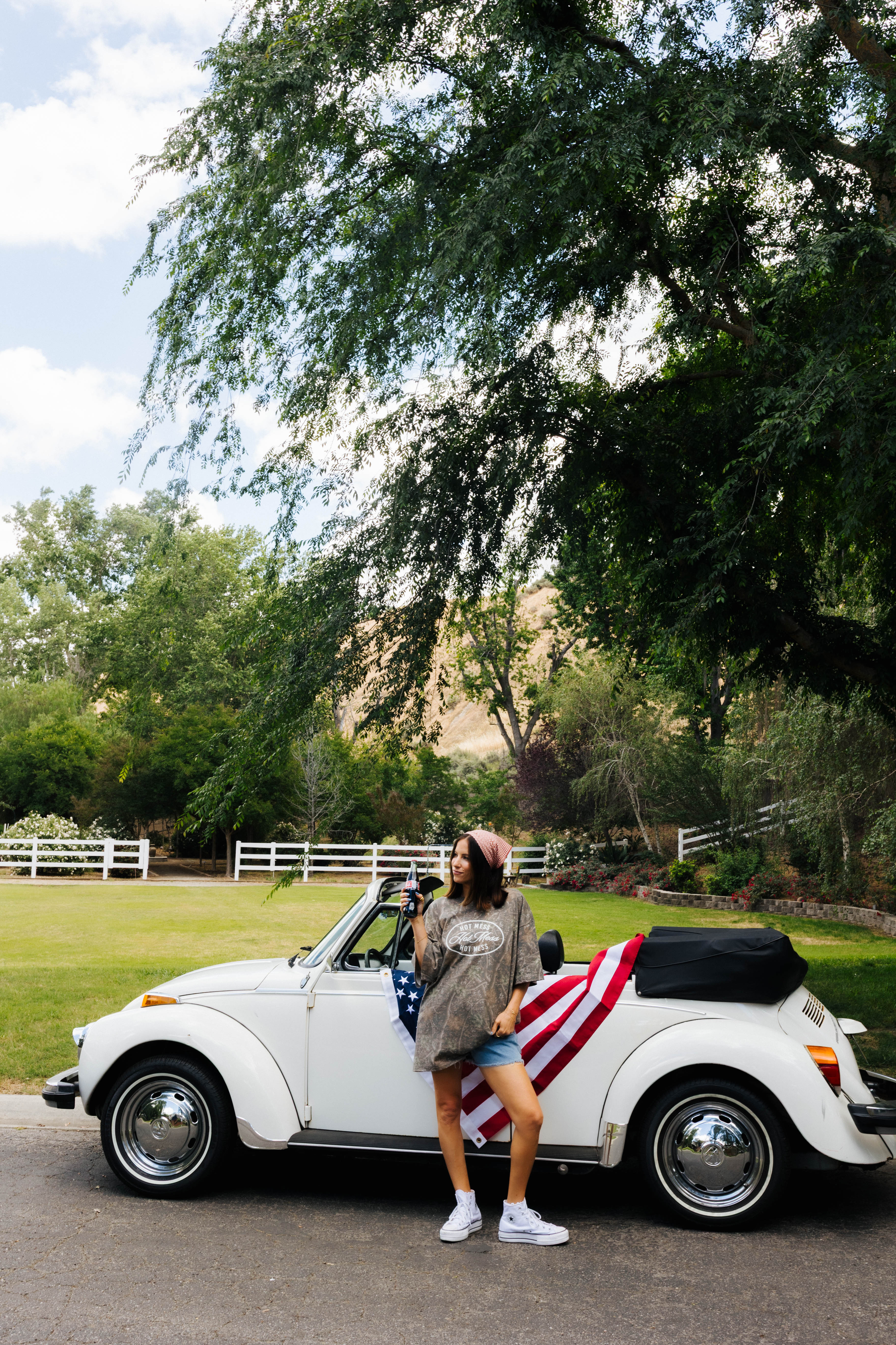 photo of Krista posing in front of the bug that has the american flag styled on it