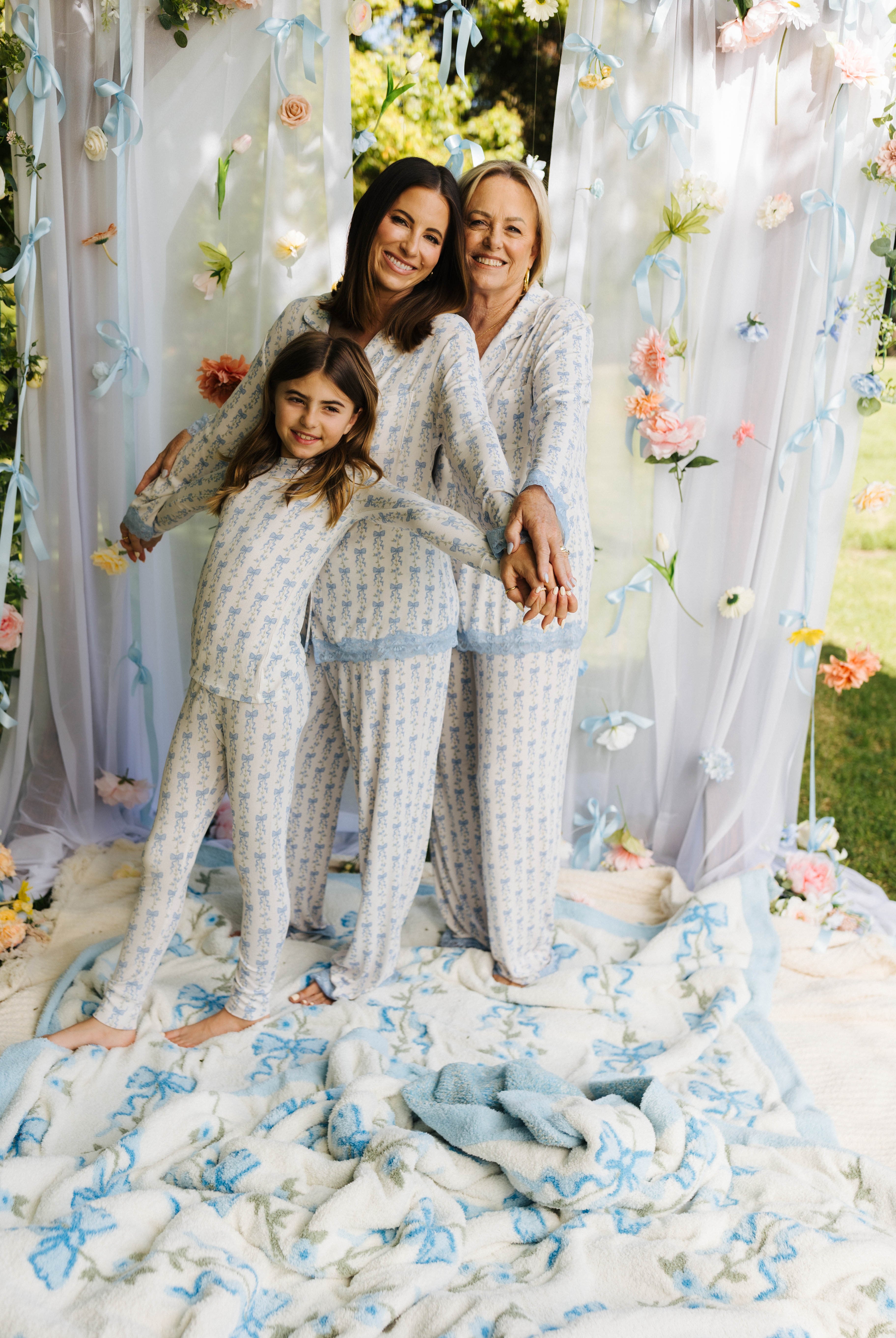 Krista Kolly and Dena holding hands posing in their matching pjs