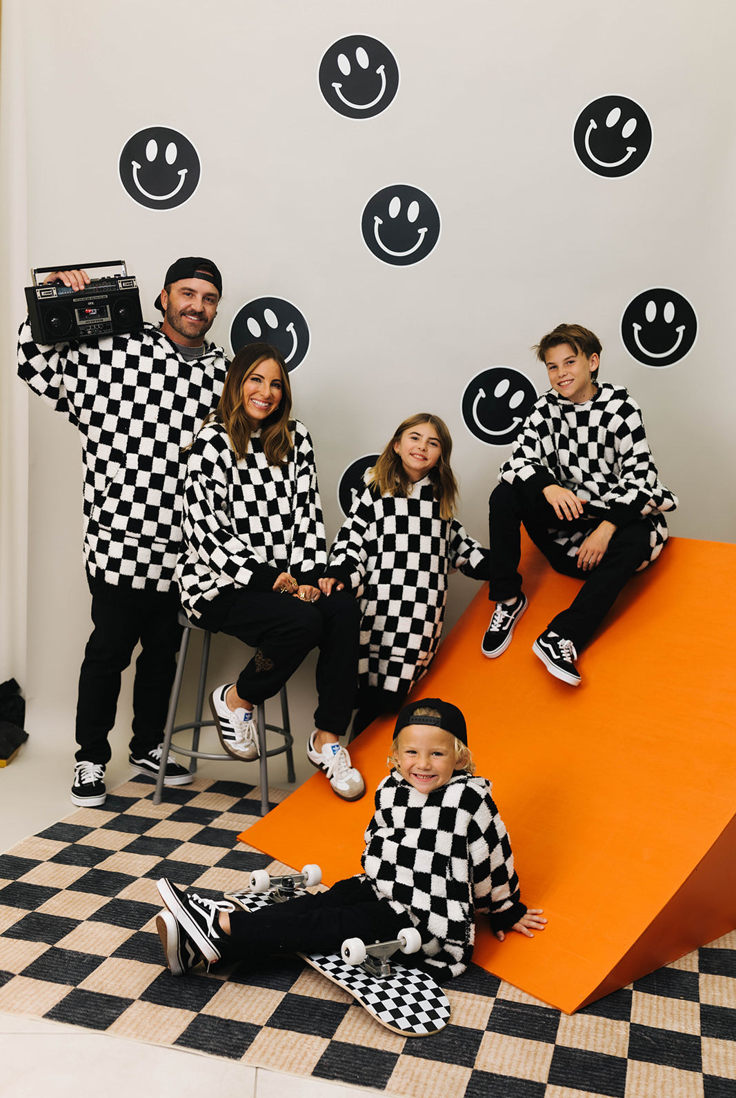 Family of five wearing checkered outfits posing
