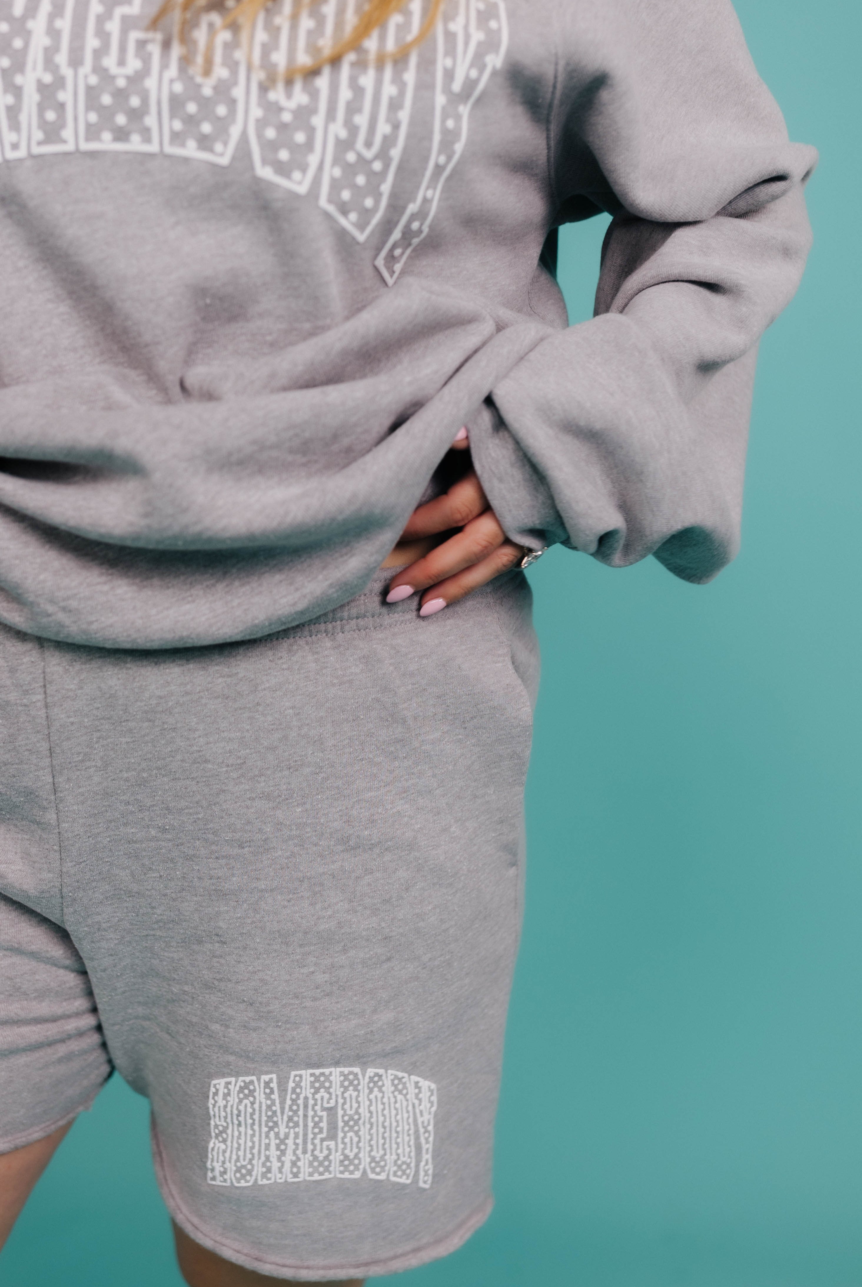 Gray sweatshirt and shorts set with text design on a teal background
