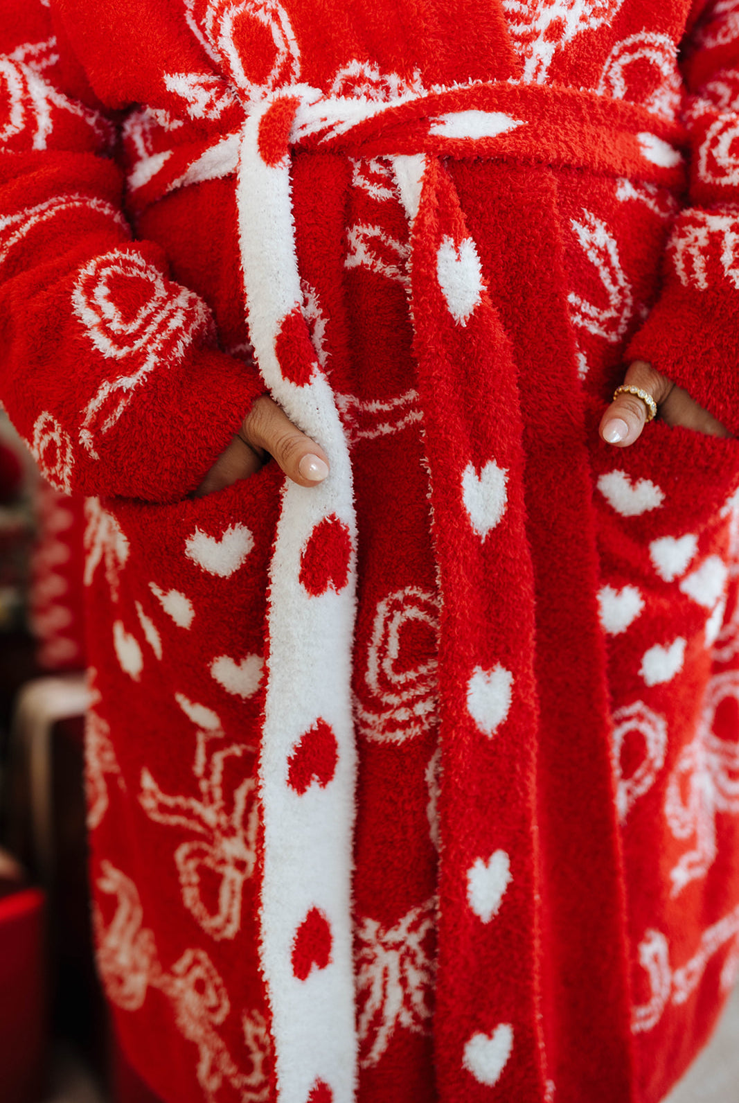 Red robe with white heart patterns worn by a person.
