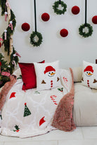 Decorative Christmas scene with a couch, pillows, and a blanket featuring festive designs.