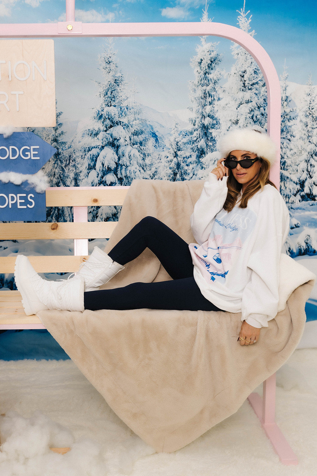Woman sitting on a pink chair with a snowy landscape in the background