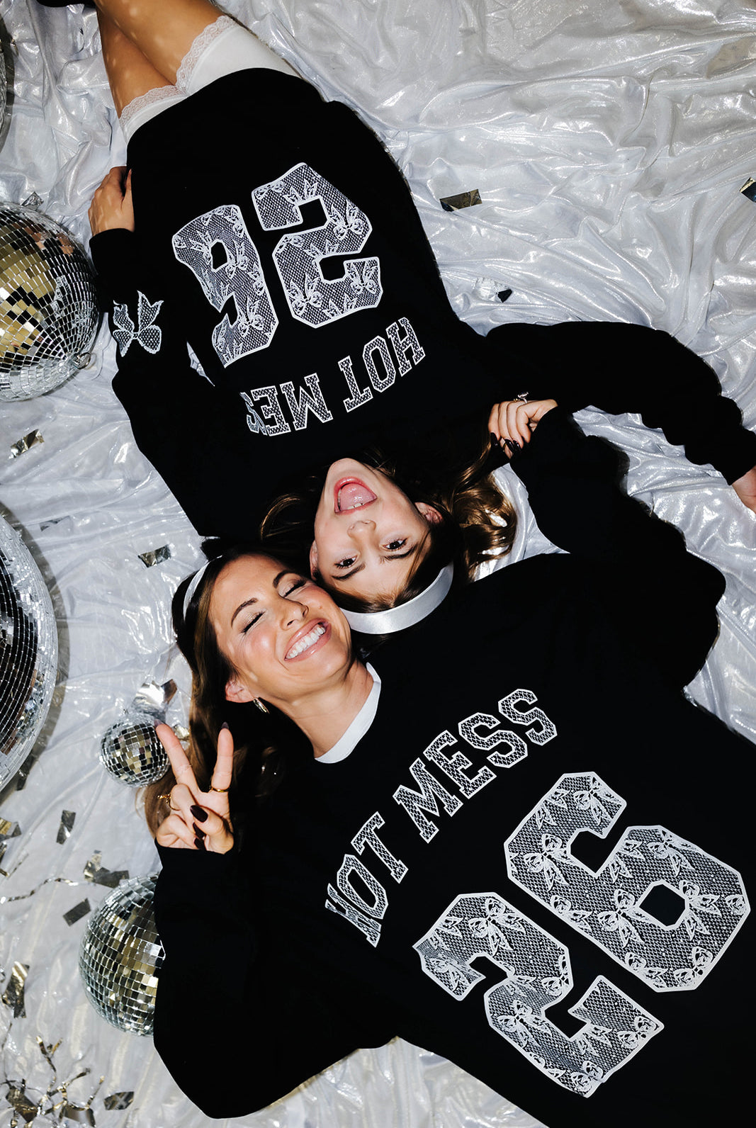 Mother and daughter laying in matching sweatshirts over a new years background