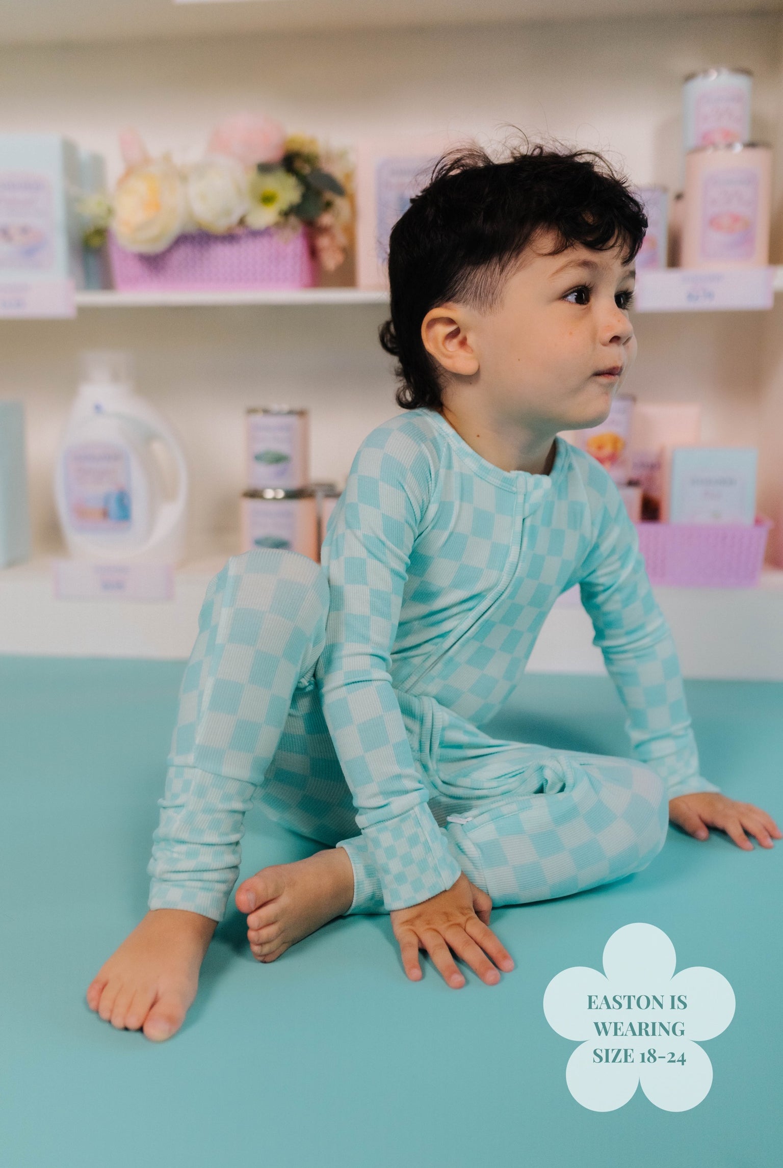 Child in a onesie teal check print