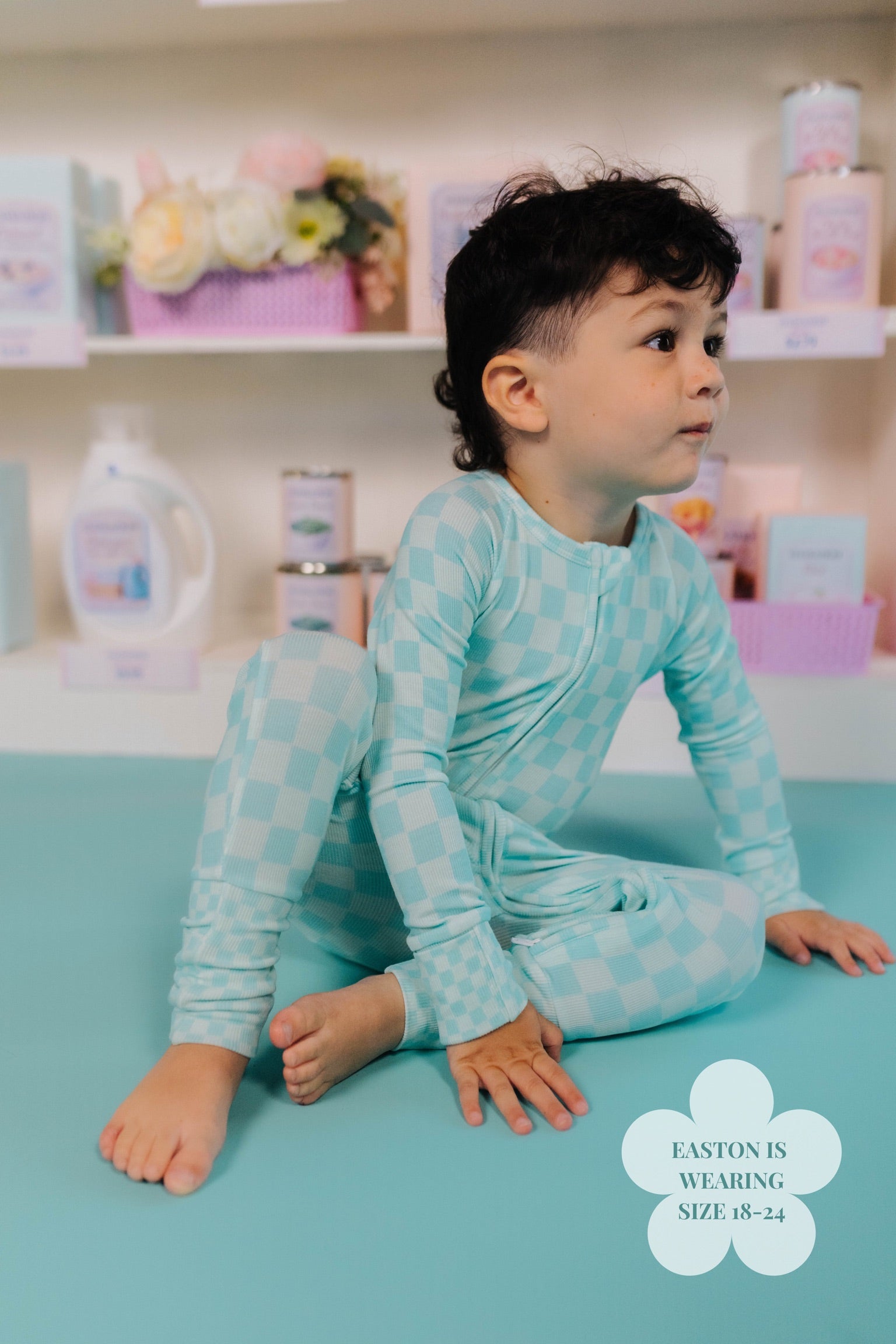 Child in a onesie teal check print