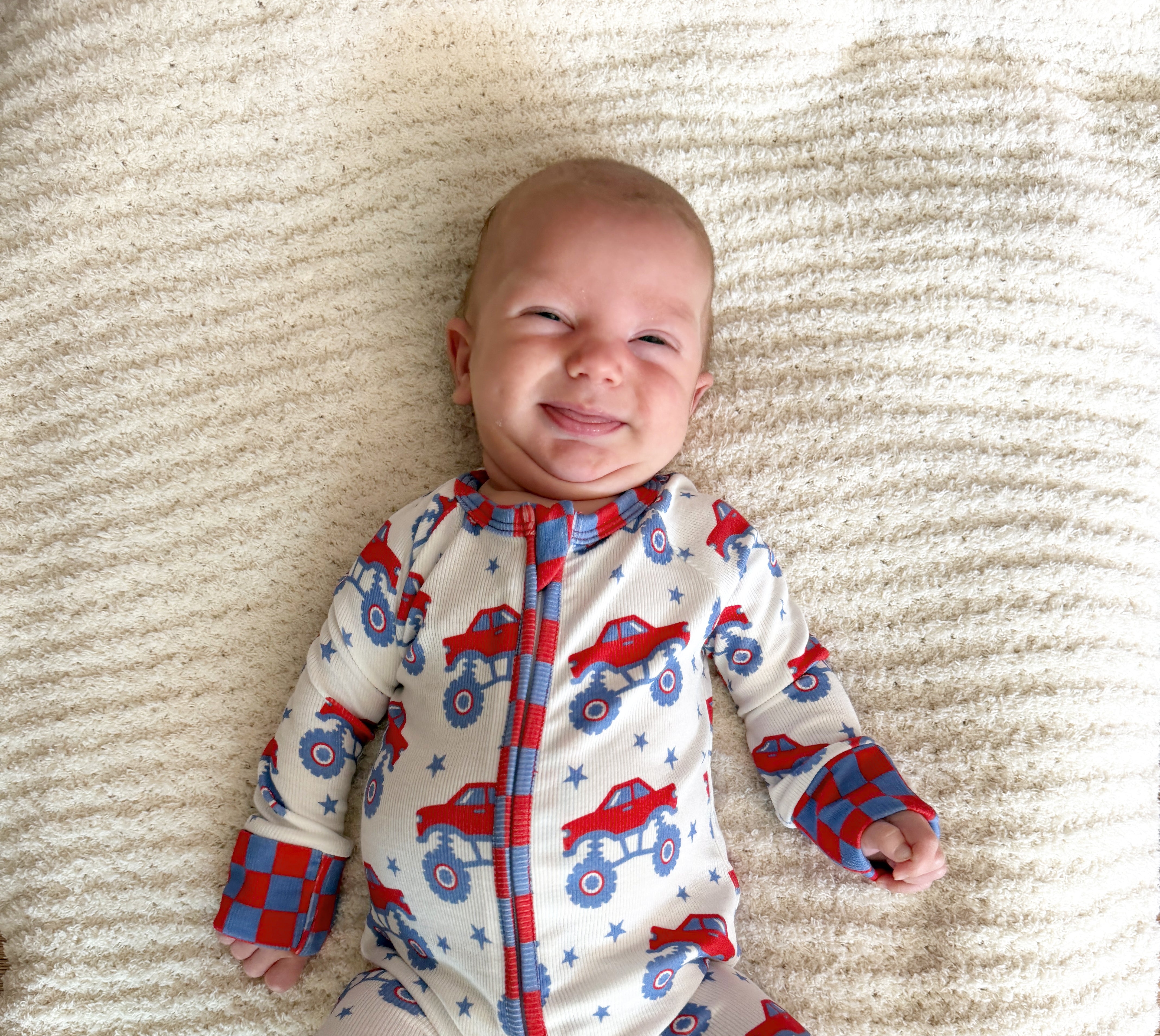 baby smiling in monster truck pjs