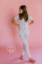 Young girl wearing in shell patterent pjs on a pink background