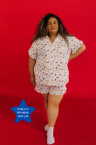Woman wearing a patterned pajama set on a red background 